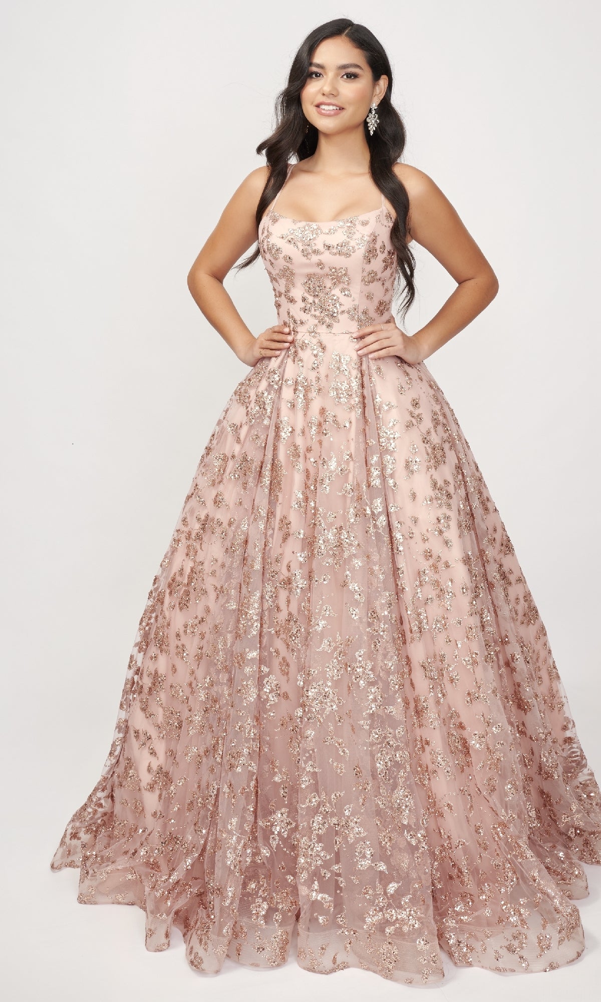 Woman standing with hands on hips, wearing the Nina Canacci 8246 Rose Gold Prom Ball Gown featuring metallic floral patterns, set against a plain light background.