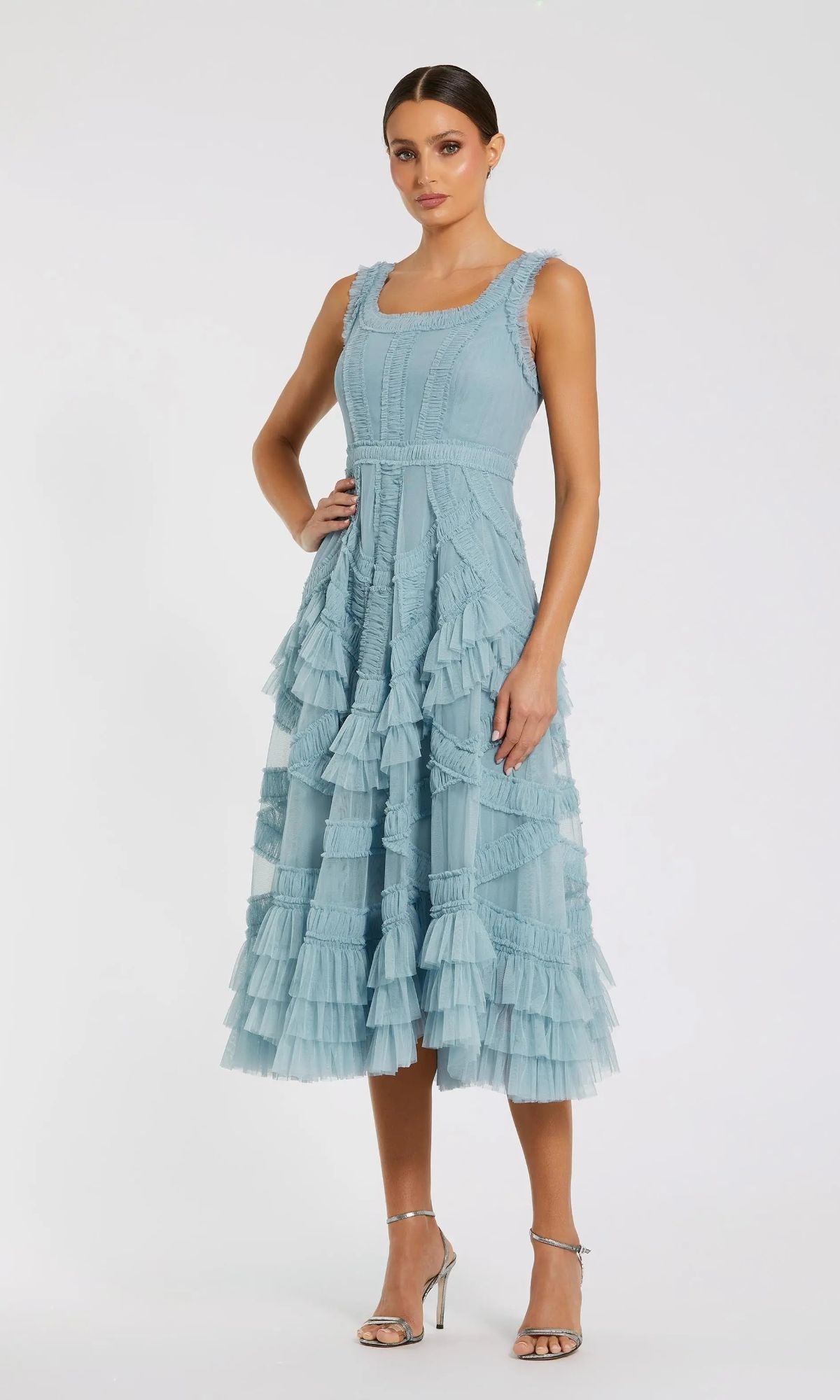 Woman wearing the Midi Wedding Guest Dress: Mac Duggal 8250 in French Blue, a sleeveless A-line with micro ruffles and tiered layers, styled with silver heels—an elegant choice for any wedding guest.
