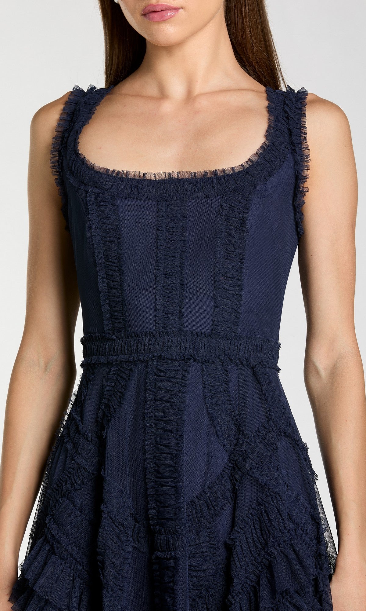 A woman models the Ruffled Midi Wedding Guest Dress: Mac Duggal 8250 in navy blue, featuring ruffle detailing and a scoop neckline, shown from shoulders to mid-thigh.