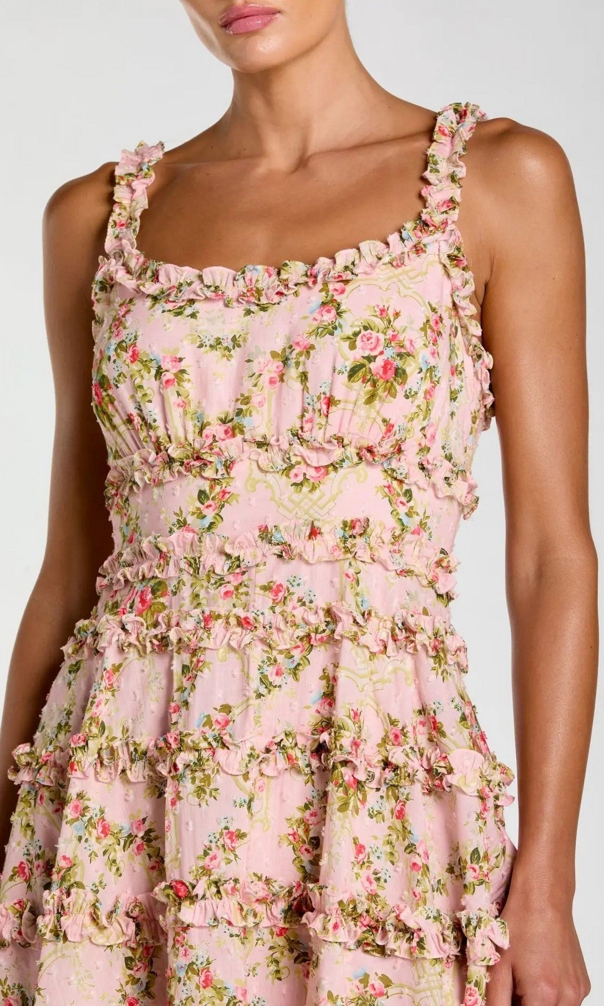 A woman wearing the Mac Duggal 8257 Ruffle Short Floral Party Dress—a pink, sleeveless party dress featuring a ruffled trim and delicate floral pattern.
