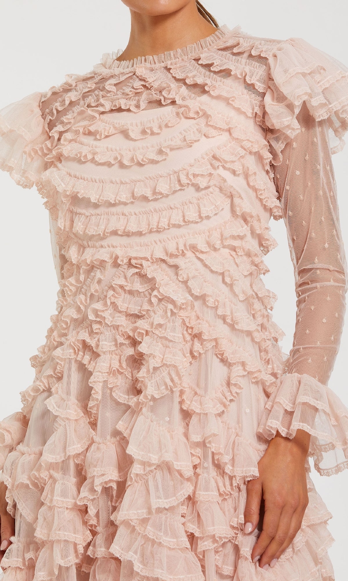Someone wears the Mac Duggal 8274 Long Sleeve Ruffle Formal Dress, a sheer pink gown featuring layers of ruffles and a subtle polka dot pattern.