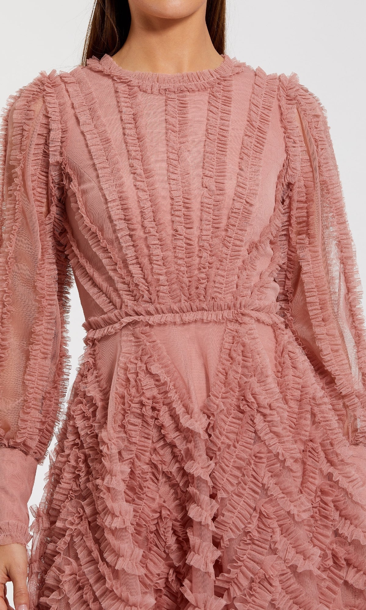 Close-up of a pink dress with long sleeves and mini ruffle detailing on a white background