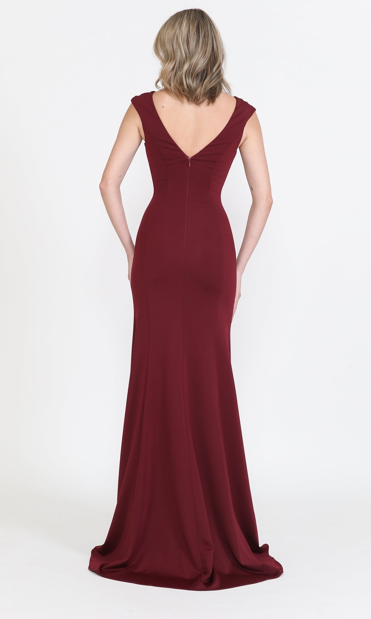 A woman wears the Cap Sleeve Long Jersey Prom Dress 8290, a floor-length burgundy gown with cap sleeves and a deep v-neck, posing against a plain white background.