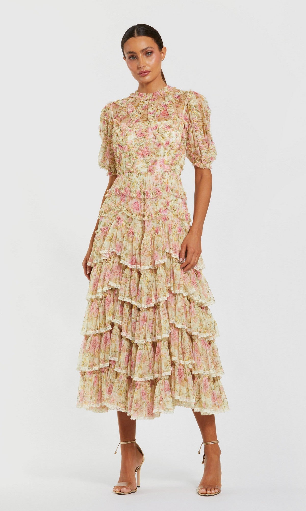 A woman stands against a plain white background wearing the Midi Wedding Guest Dress: Mac Duggal 8295 in Ivory Multi, featuring floral mesh fabric, puff sleeves, ruffle details, and nude high-heeled sandals.