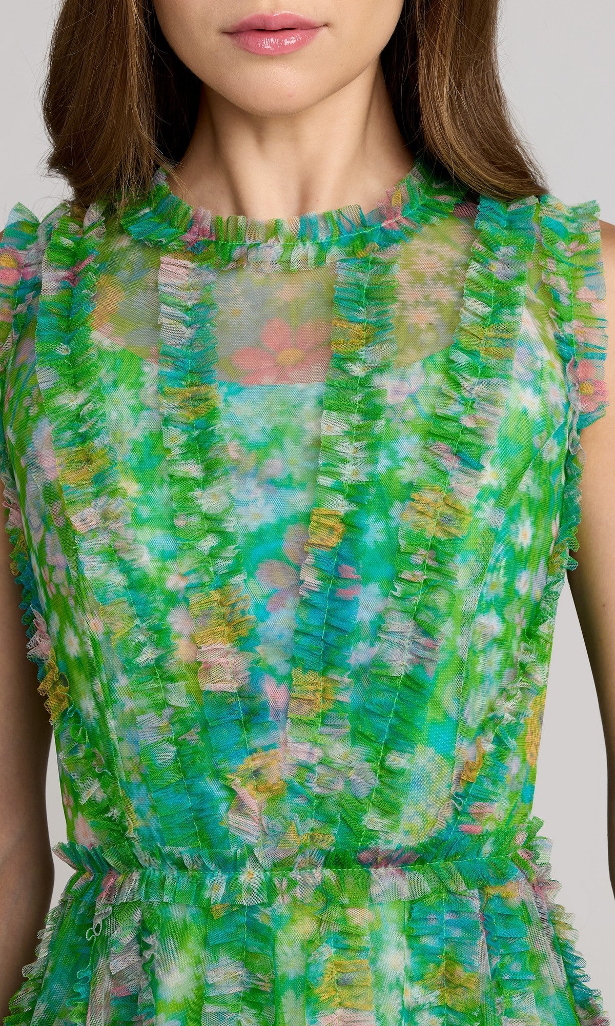 Woman wearing the Mac Duggal 8307 High-Neck Print Wedding-Guest Dress, a sleeveless green floral-print style with vertical ruffled details, shown from shoulders to waist.