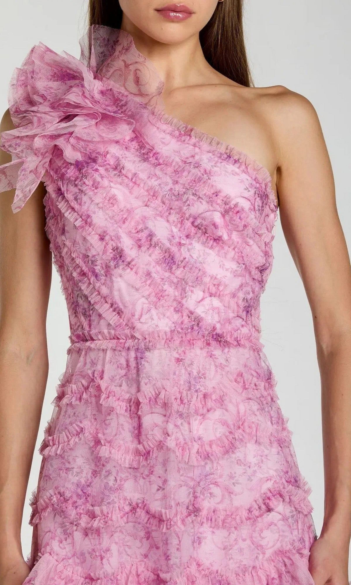 A person wearing the Mac Duggal 8422 tea-length party dress in pink, featuring a sleeveless, one-shoulder design with ruffled floral fabric details.