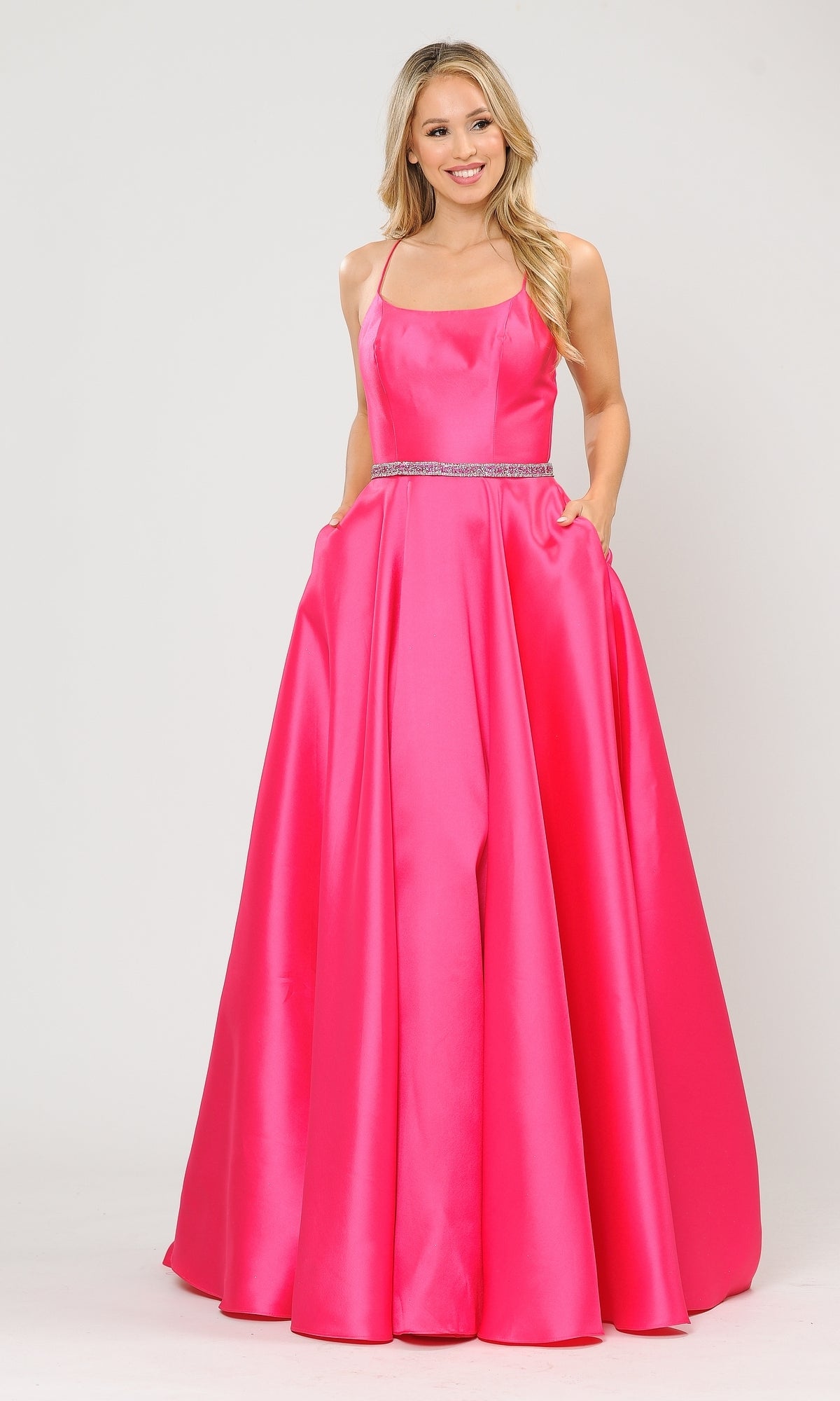 A woman poses against a plain light background in the fuchsia Scoop-Neck Long A-Line Prom Dress with Pockets 8684, featuring thin straps, a fitted bodice, pockets, and jeweled waist detail.