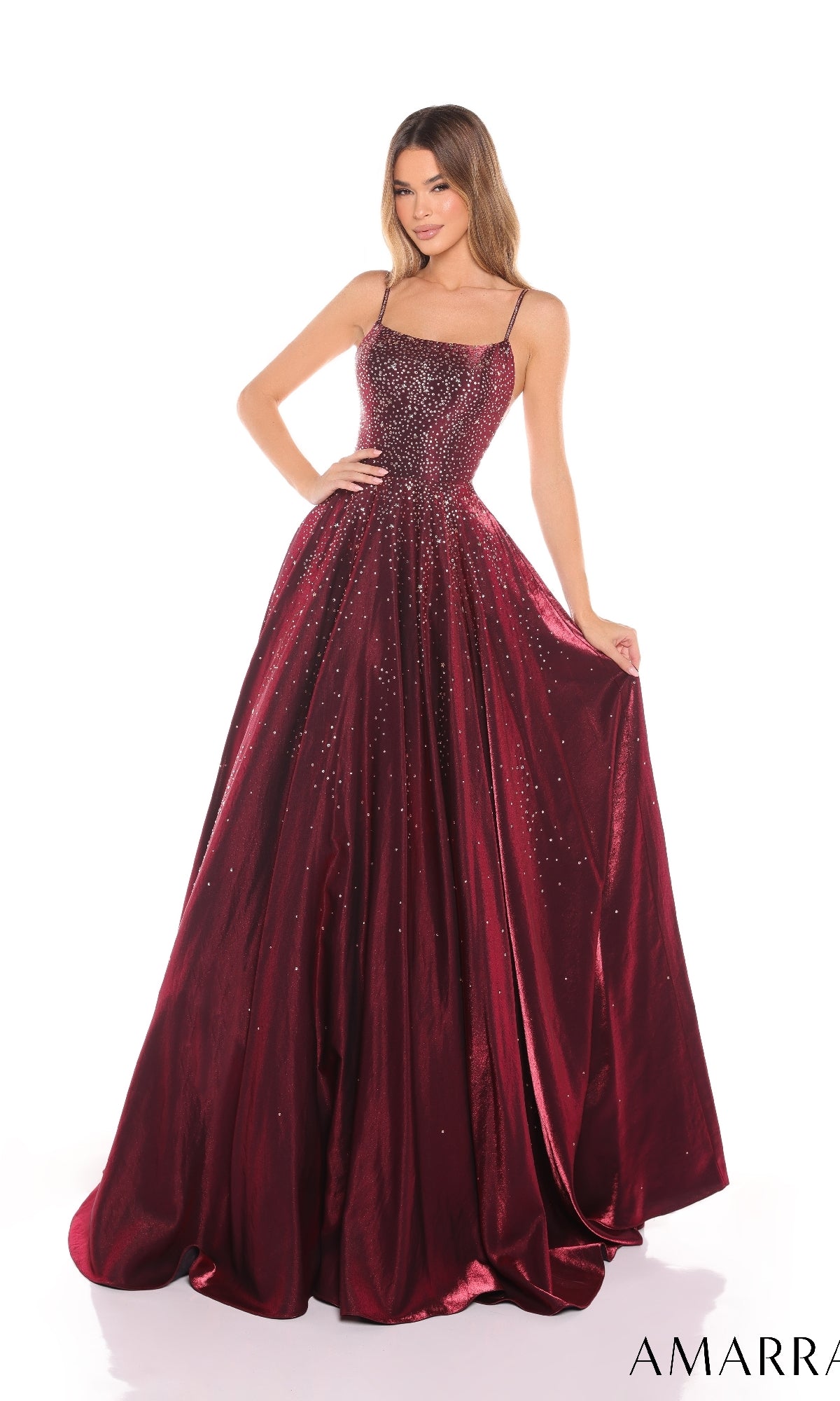A woman wears the Amarra 87292 long prom dress, featuring a sleeveless, sparkling bodice and a full satin A-line skirt, standing against a white background.
