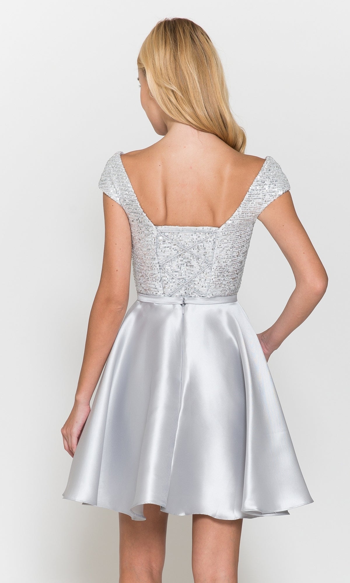 A woman is shown from the back wearing the Cap-Sleeve Short A-Line Homecoming Dress 8732, a silver sequin party dress with a fitted bodice, cap sleeves, and a satin flared skirt.