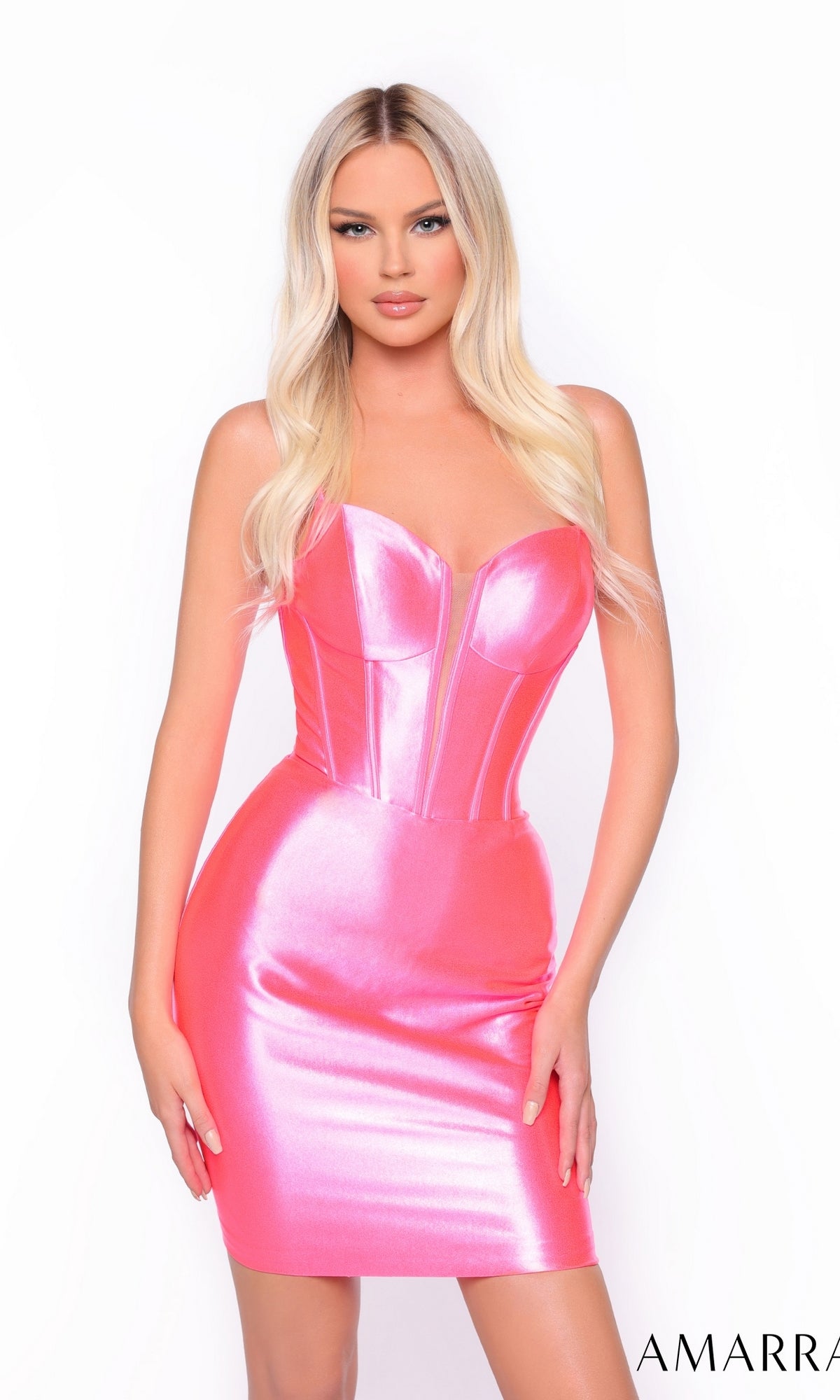 A woman with long blonde hair wears the Short Homecoming Dress 88076 by Amarra, a shiny pink fitted dress with a structured boned corset bodice, standing against a plain white background.