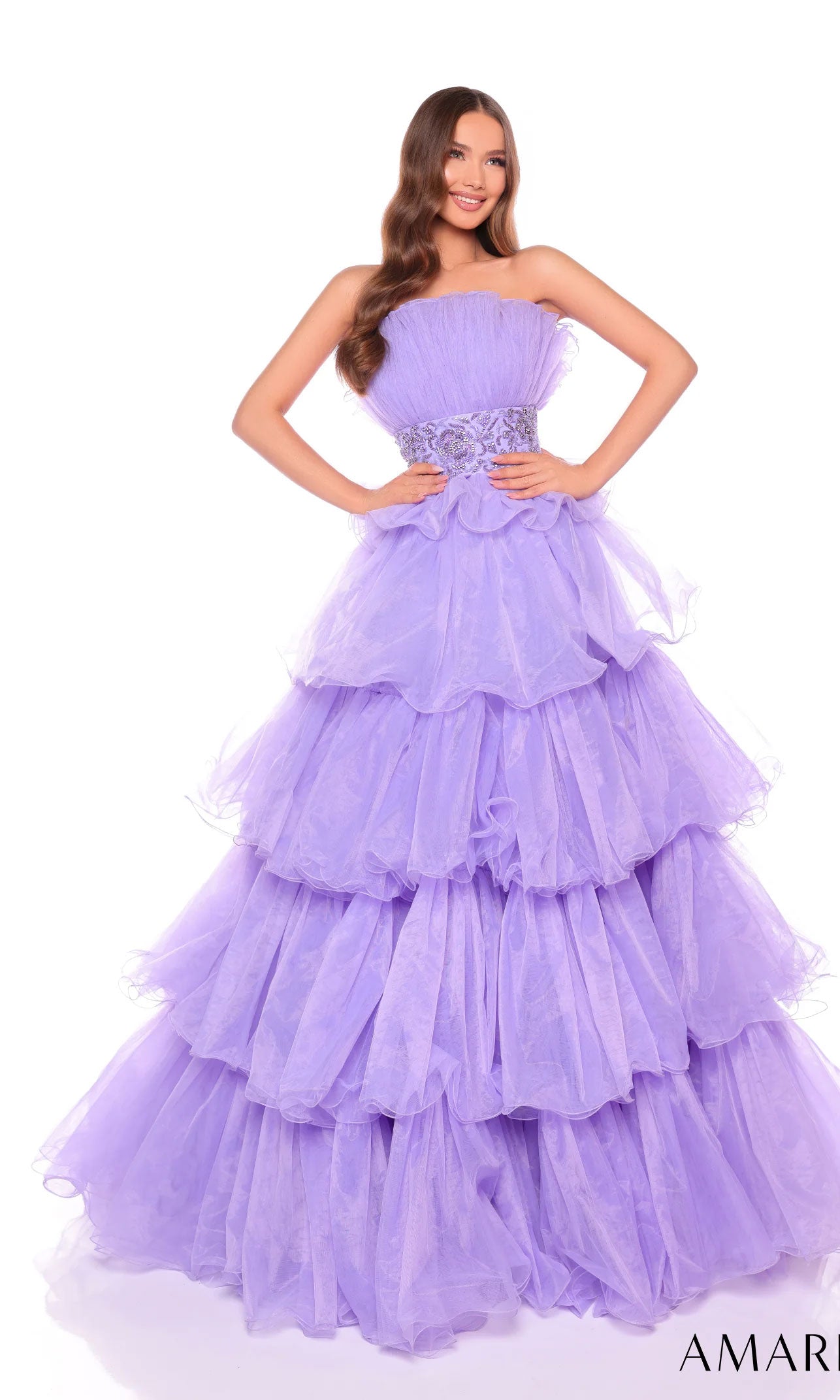A woman poses against a white background in the Long Formal Dress 88083 by Amarra, featuring a strapless design, beaded waist, layered ruffles, and a lavender floral belt.