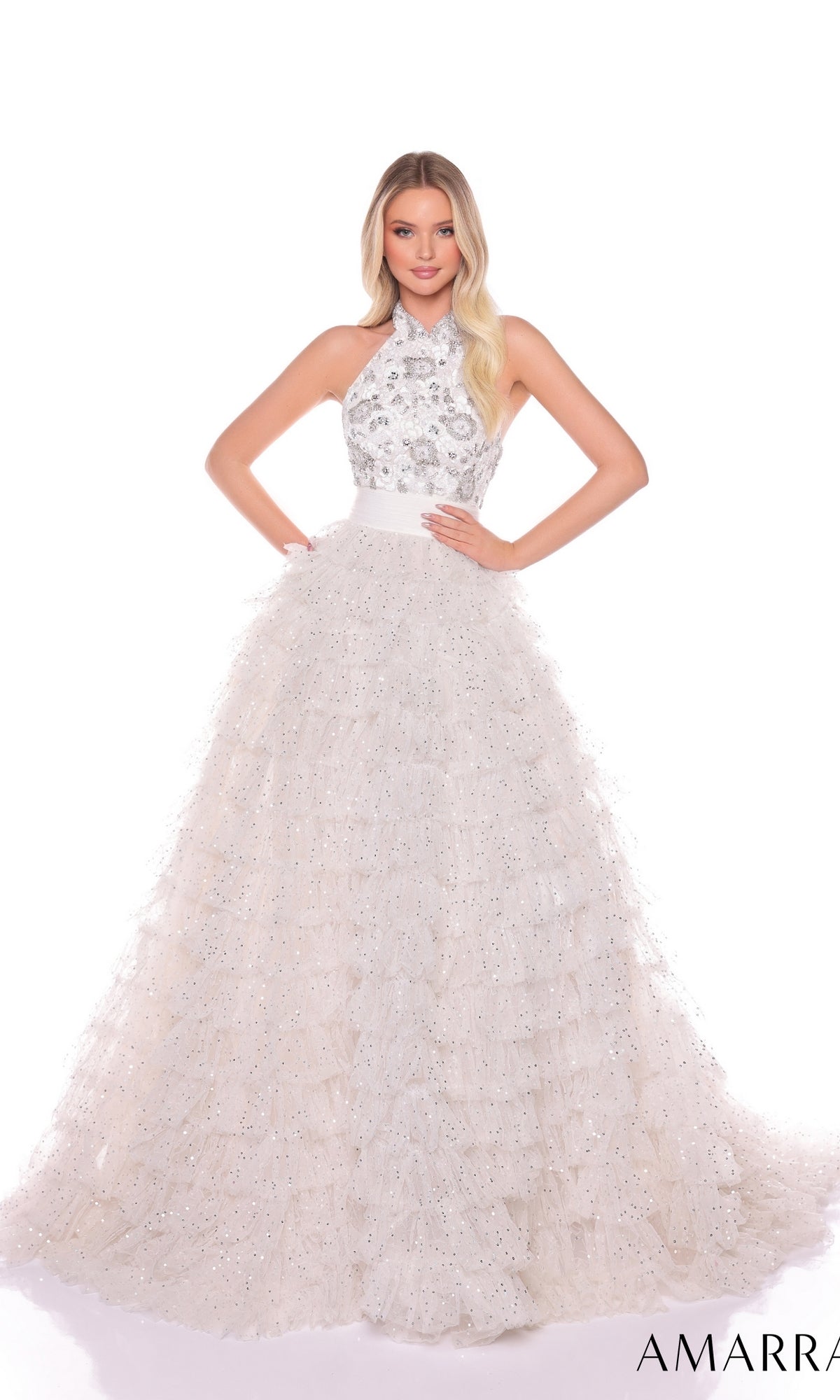 A woman stands wearing the Amarra Long Formal Dress 88102, featuring a sleeveless halter neck, fitted beaded bodice, and a ruffle layered skirt with sparkling details.