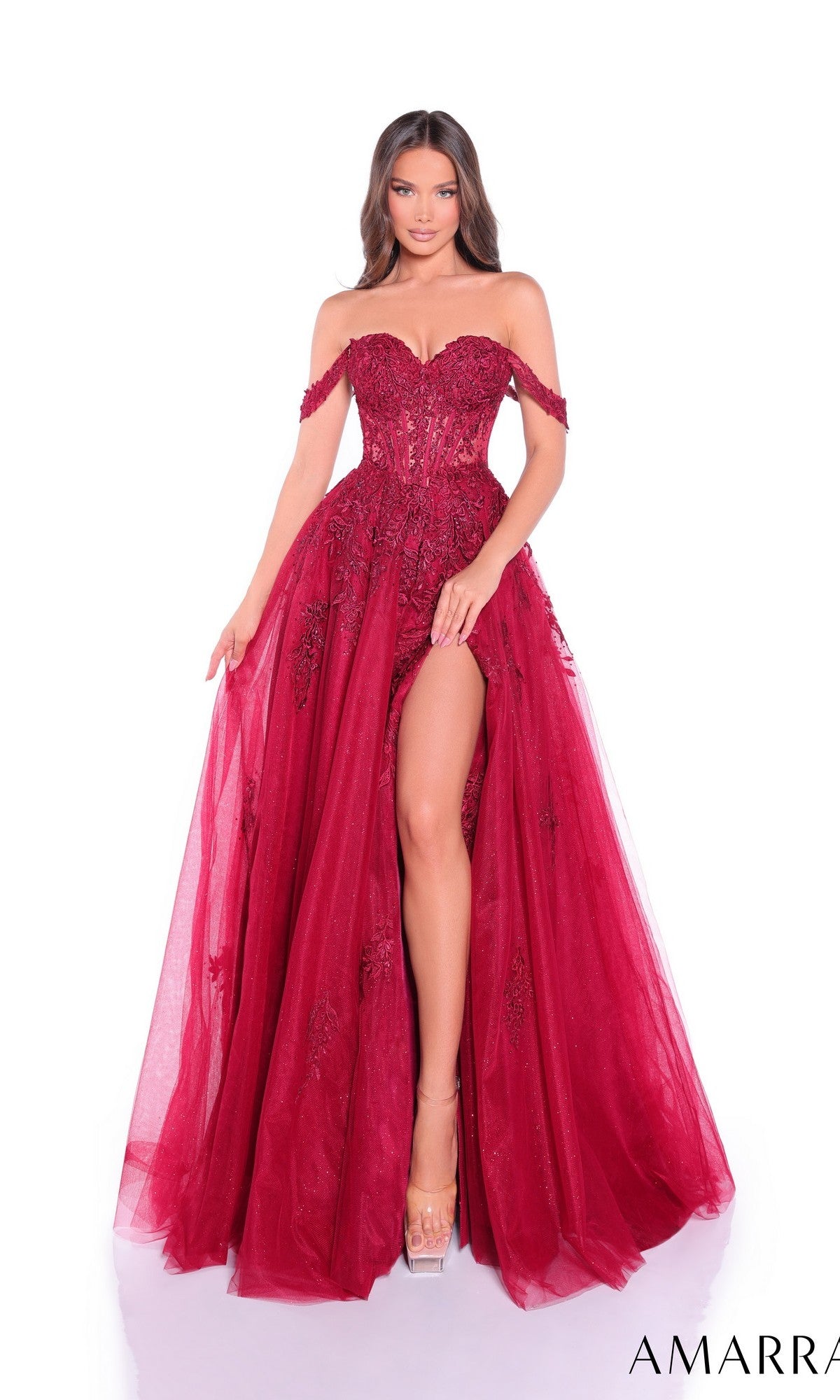 A woman models the Amarra 88963 Off-Shoulder Corset Prom Ball Gown in deep red, with a fitted bodice, sheer corset overlay, and high slit, standing against a white background.