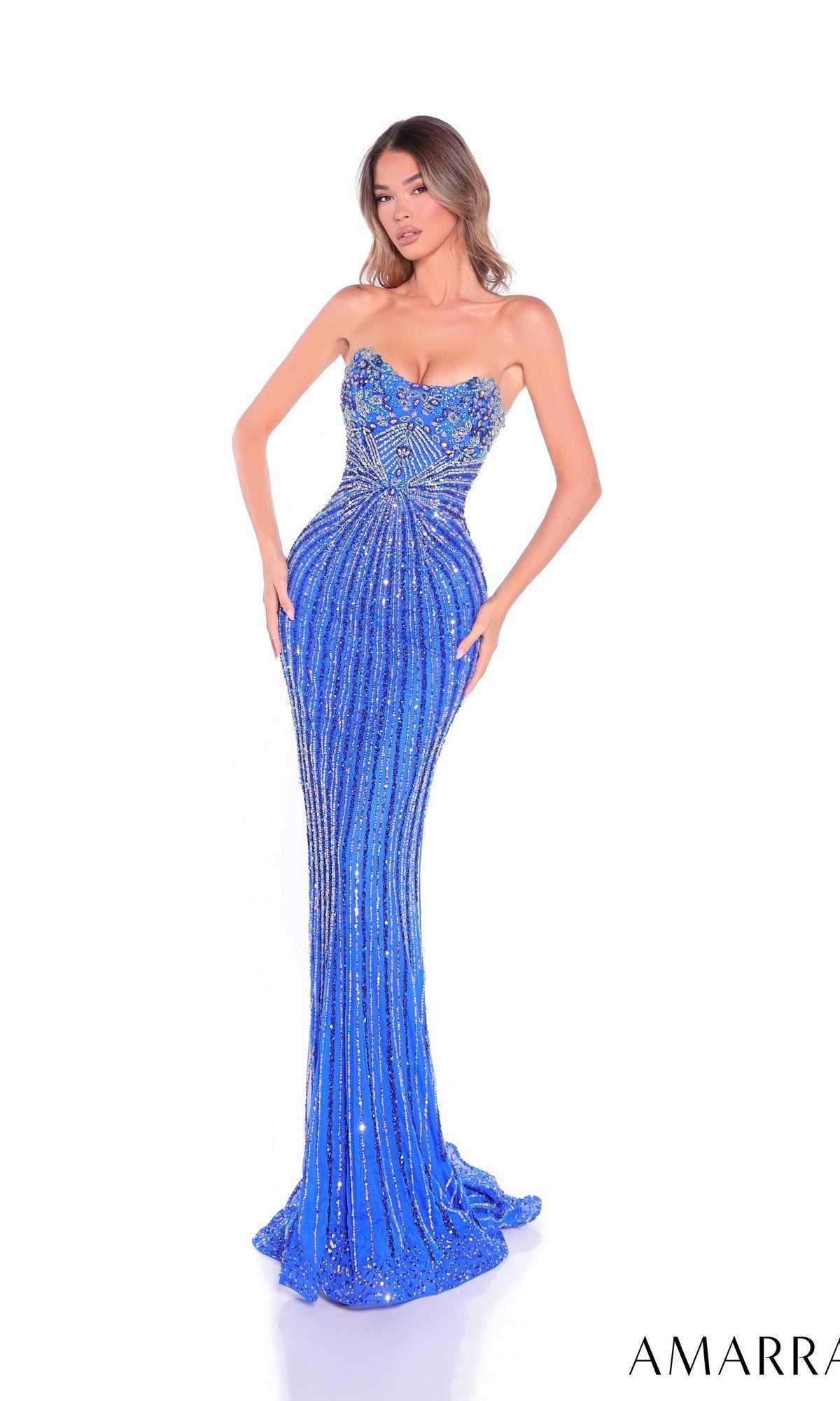 A woman models the Amarra 89089 long prom dress—a strapless, form-fitting, royal blue sequin gown with intricate beadwork and a lace-up back—standing against a white background. The AMARRA brand logo appears in the lower right corner.