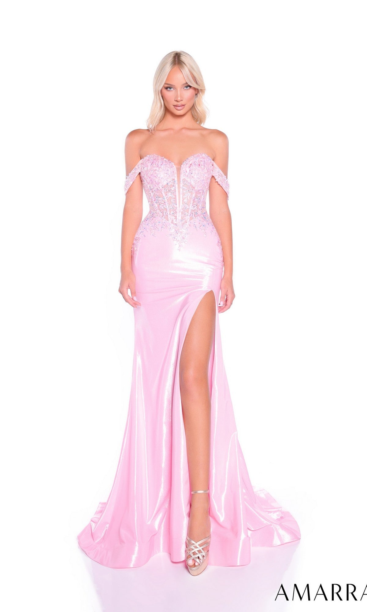Model wearing the Amarra 89092 long prom dress, a shiny light pink off-the-shoulder gown with a lace corset bodice and high-leg slit, styled with silver heels, posing against a white background.