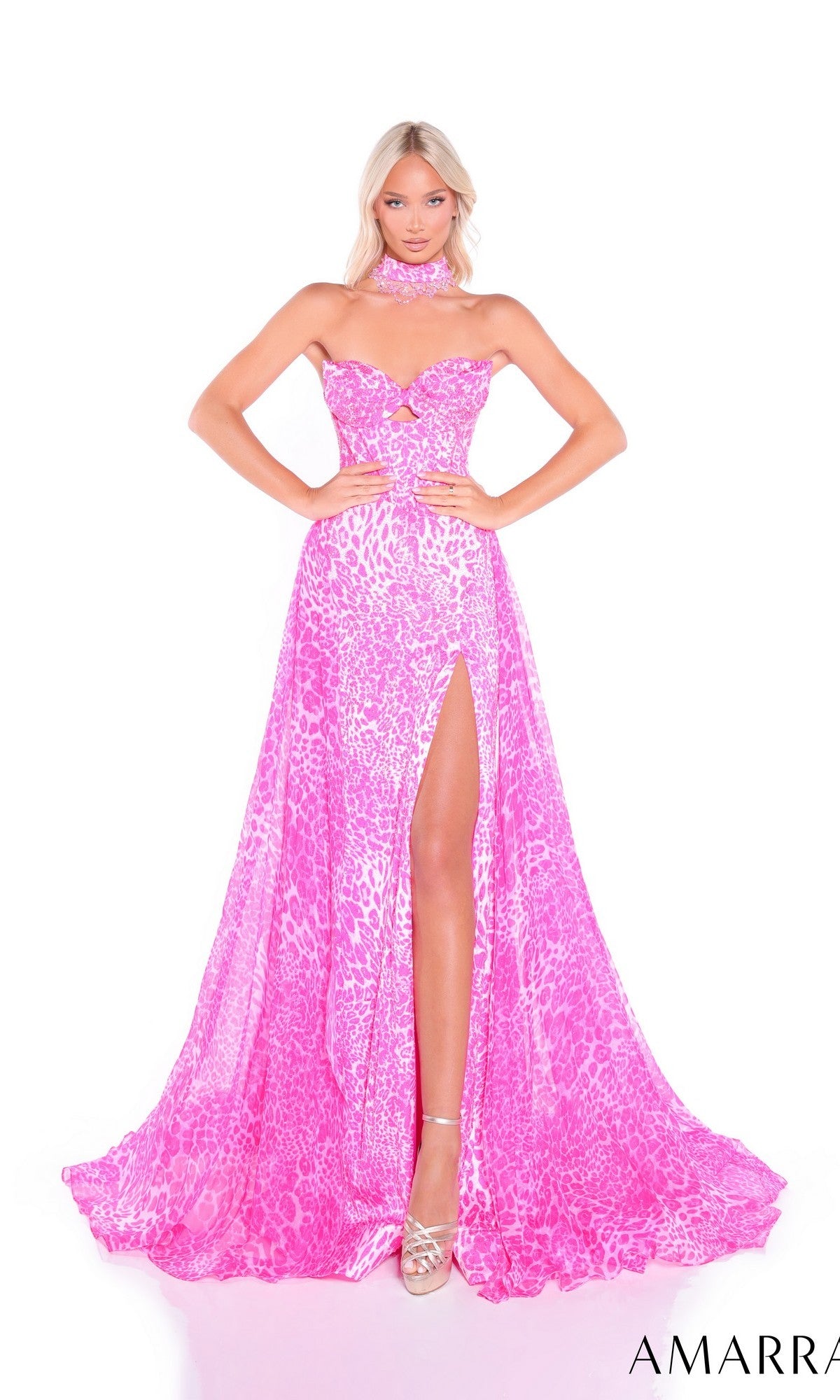 A woman poses in the Amarra 89395 long prom dress featuring a strapless pink leopard print, high slit, and matching neck scarf against a white background.