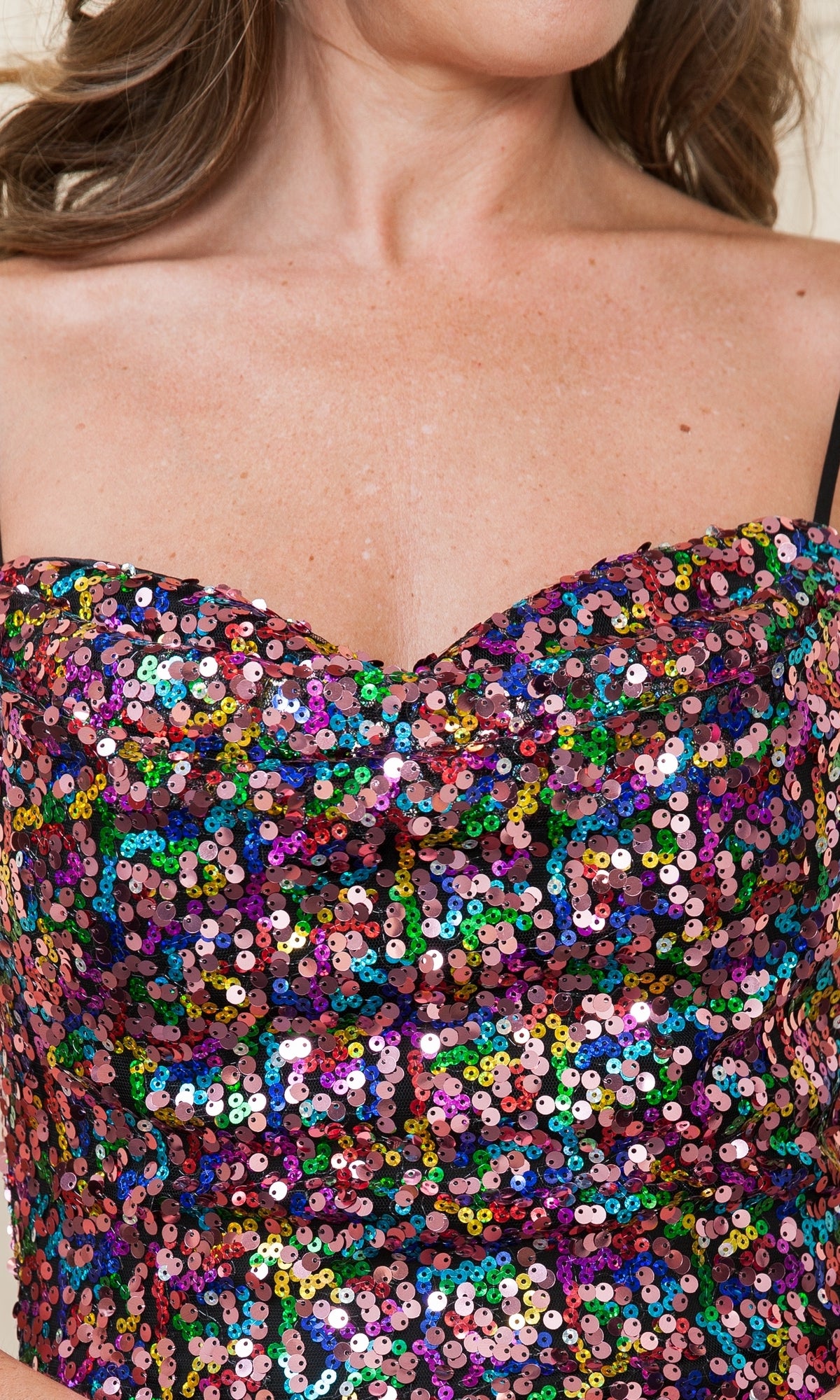 A woman wears the Multicolored Short Sequin Homecoming Dress 8944, a strapless sweetheart party dress with vibrant sequins and visible black bra straps.