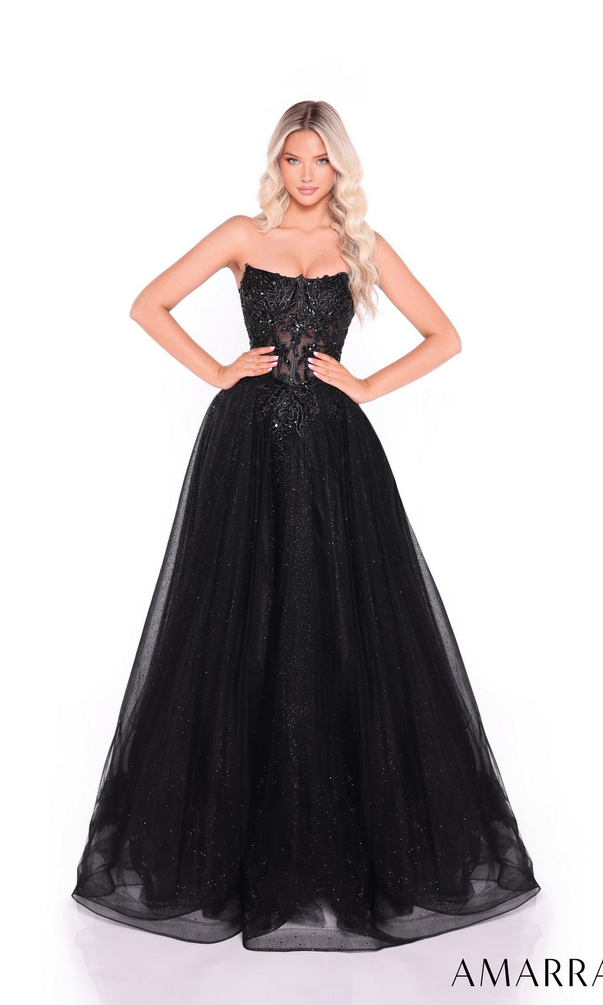 A woman stands against a plain white background wearing the Amarra 89486 Long Prom Dress, a strapless glitter tulle gown with a fitted, embellished bodice and lace embroidery.