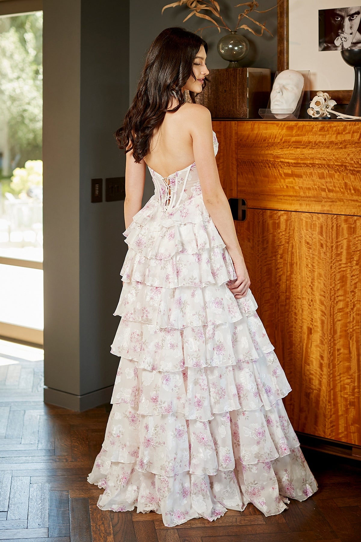 Back view of the Long Floral Prom Dress: Amelia Couture 9105, featuring a floor-length purple floral print and a lace-up corset bodice.