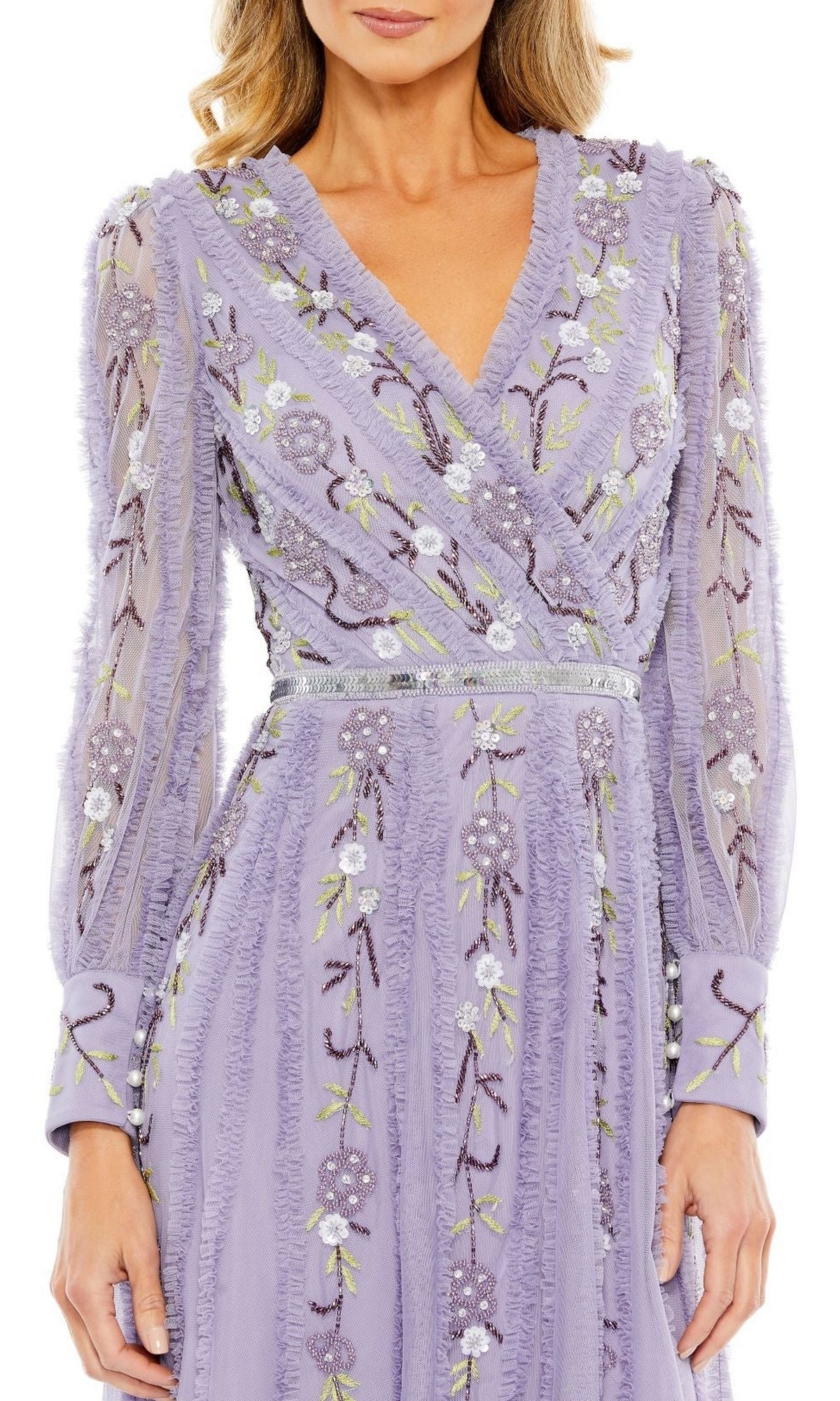 A woman wearing the Mac Duggal Knee Length Wedding Guest Dress 9133 with long sleeves, a V-neckline, floral embroidery, a fitted waist, and a lavender semi-formal design.