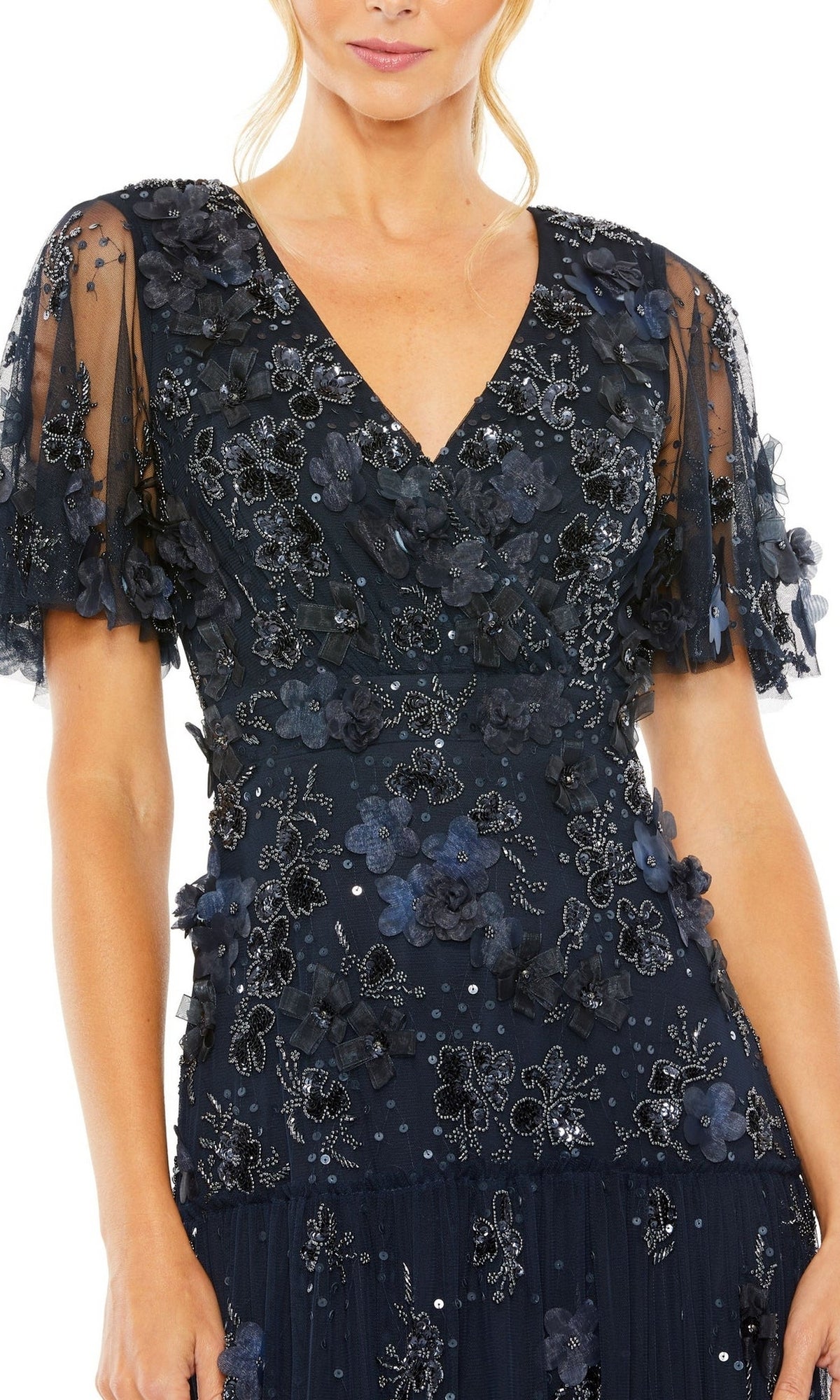 Woman wearing the Mac Duggal 9207 A-Line Wedding Guest Dress in navy blue, featuring short sheer sleeves and floral appliqué, shown from shoulders to mid-thigh.