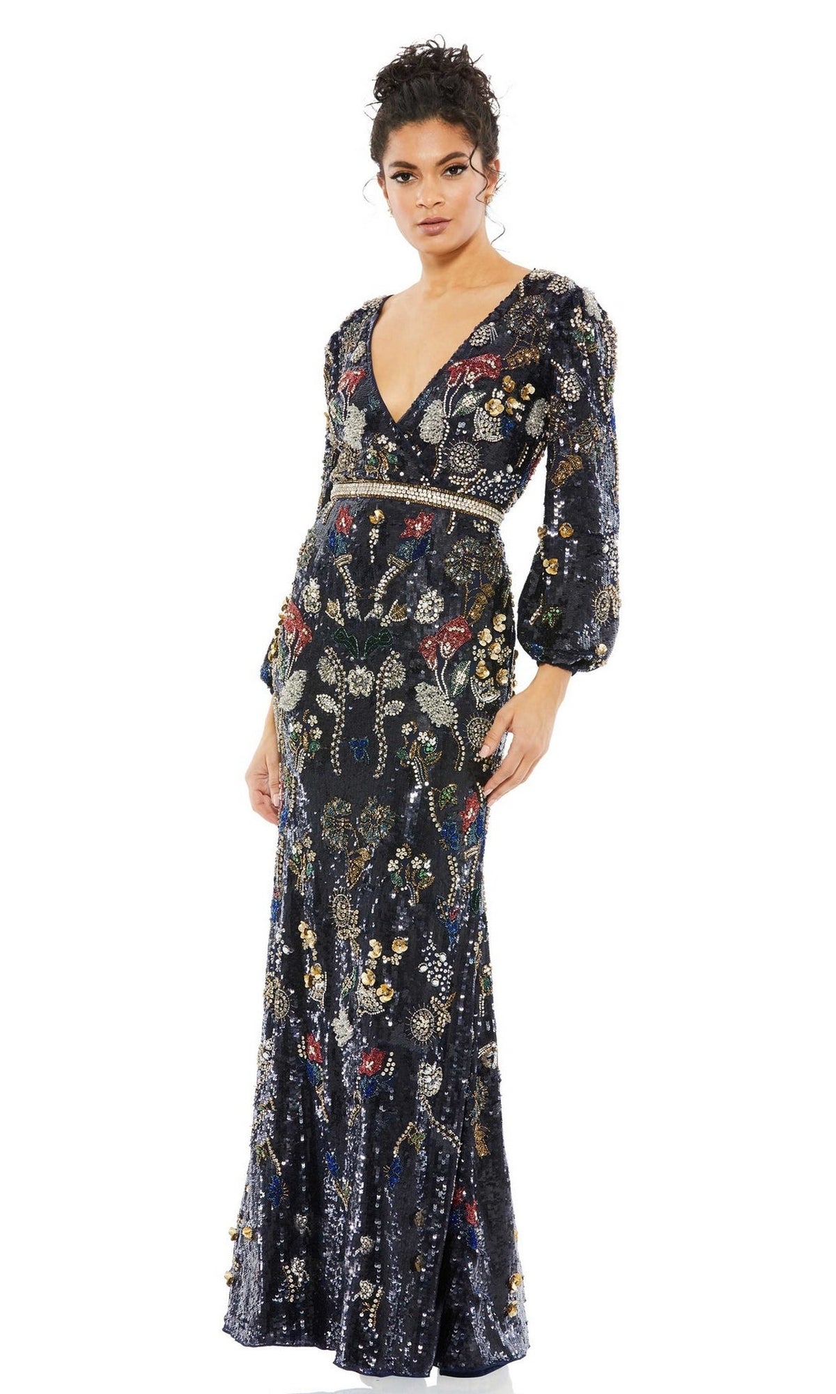 A woman wearing the Long Formal Dress 93546 by Mac Duggal, featuring a deep v-neckline, long sleeves, and colorful embroidered and beaded details, stands against a white background.