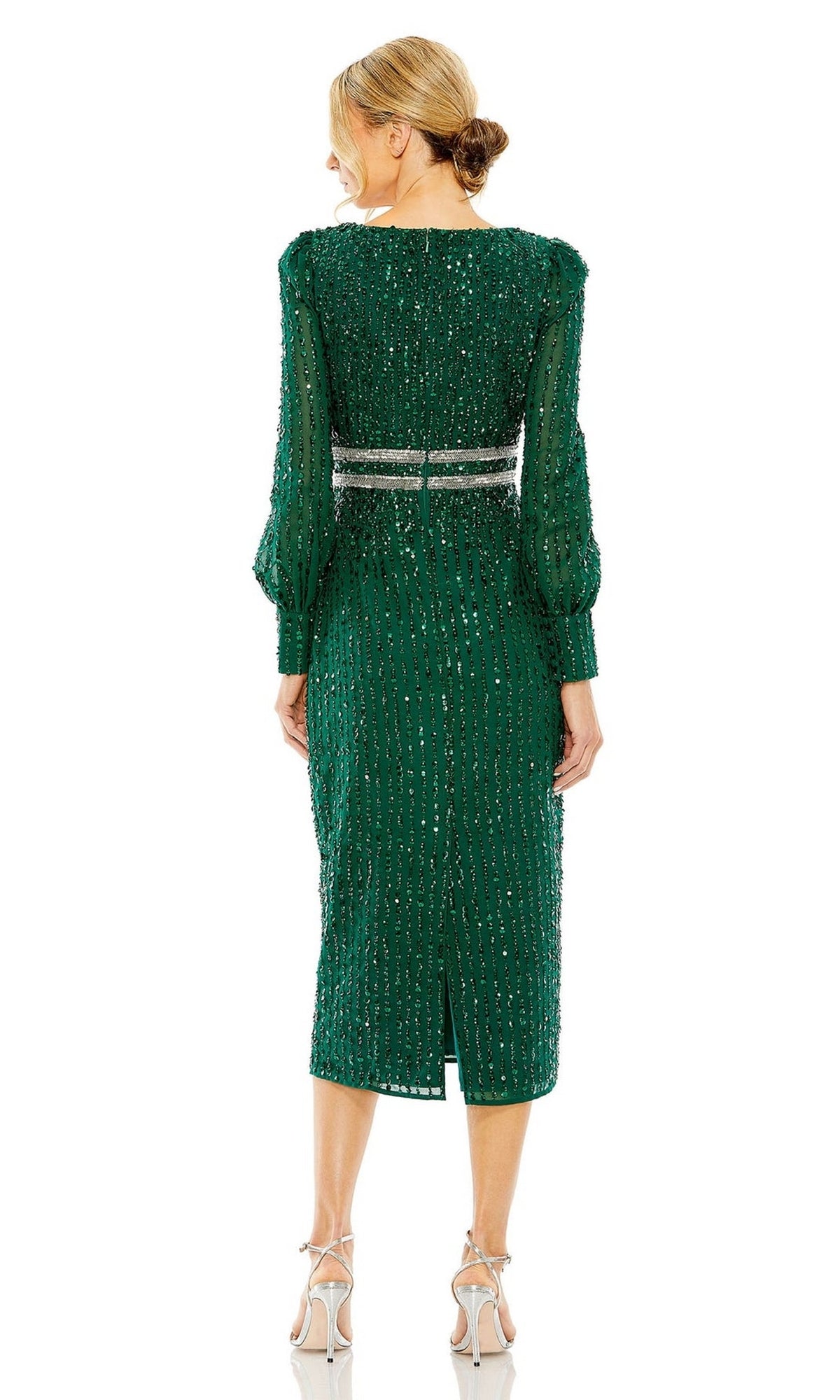 A woman faces away, wearing the Mac Duggal 93593 knee-length wedding guest dress in green with long sleeves, beaded accents, a silver belt, and light heels.