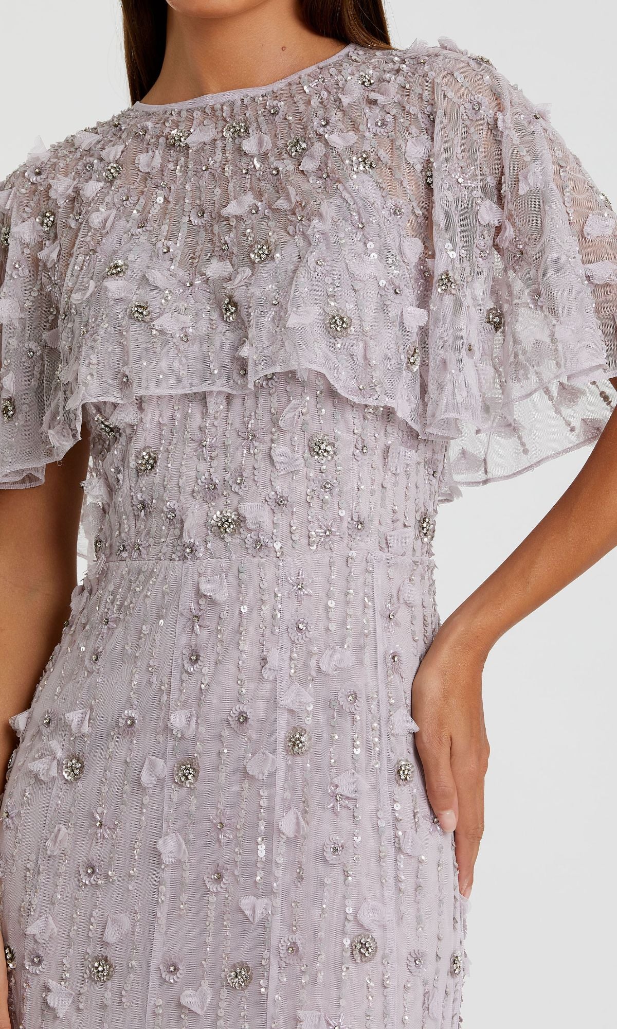 A woman wearing the Mac Duggal 93653 Beaded-Cape Long Formal Dress in light lavender, featuring sheer ruffled sleeves with intricate beaded and floral embellishments.