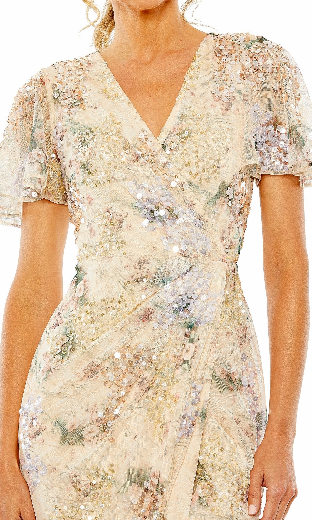 A woman wears the Mac Duggal 93749 Short Sleeve Beaded Formal Dress, featuring light floral sequins, flutter sleeves, a V-neckline, and a gathered waist for an effortlessly elegant look reminiscent of evening wear.