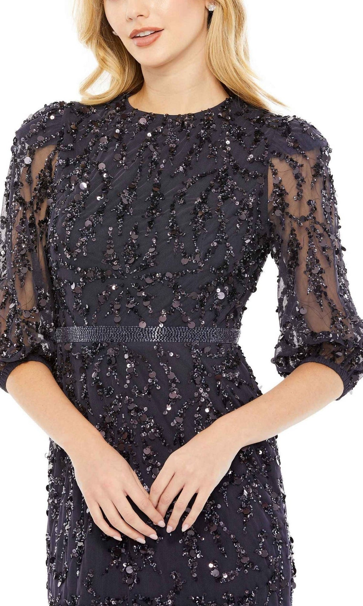 Woman wearing the Mac Duggal 93790 Long Sleeve Beaded Formal Dress, featuring elegant beading and a high neckline—a sophisticated style with three-quarter sleeves and hands clasped in front.
