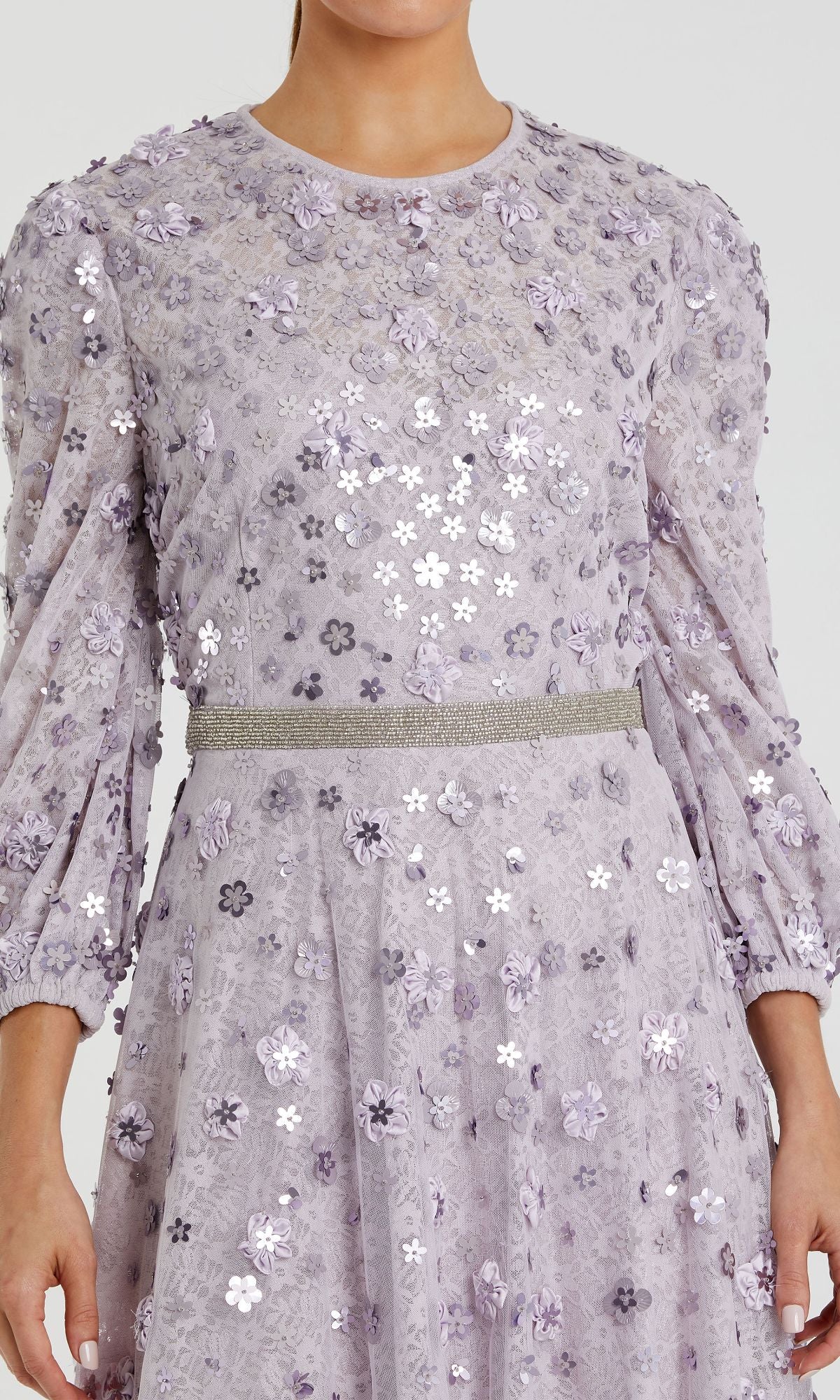 Someone is wearing the Mac Duggal 93805, a modest long sleeve formal dress in light purple with floral embroidery, sequin accents, and a silver belt.