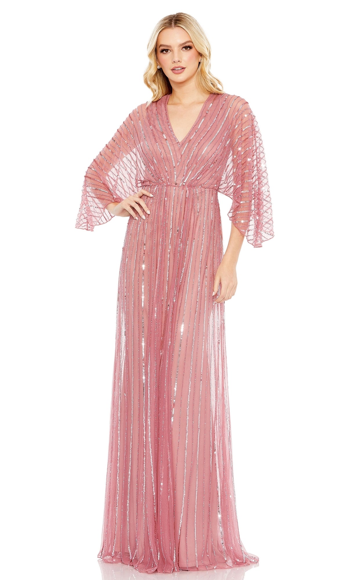 A woman stands facing forward in the Mac Duggal 93841 Long Sequin A-Line Formal Dress, featuring floor-length pink sheer fabric, sequin stripes, wide sleeves, and a V-neckline against a white background.