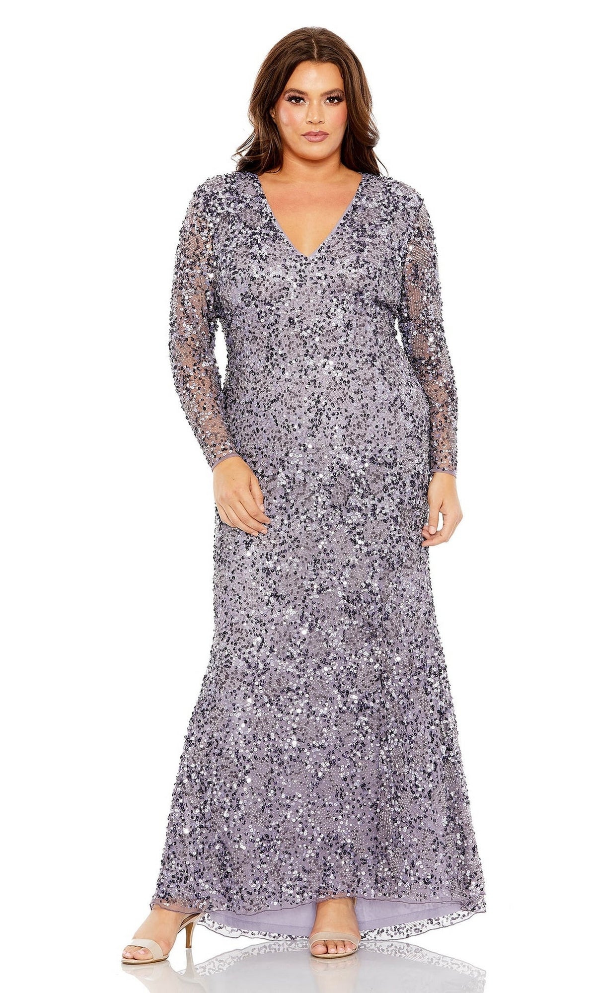 A woman wears the Long Plus-Size Prom Dress 93865 by Mac Duggal—a vintage-inspired, floor-length sequin v-neck gown with long sleeves—paired with nude heels, standing facing forward against a white background.