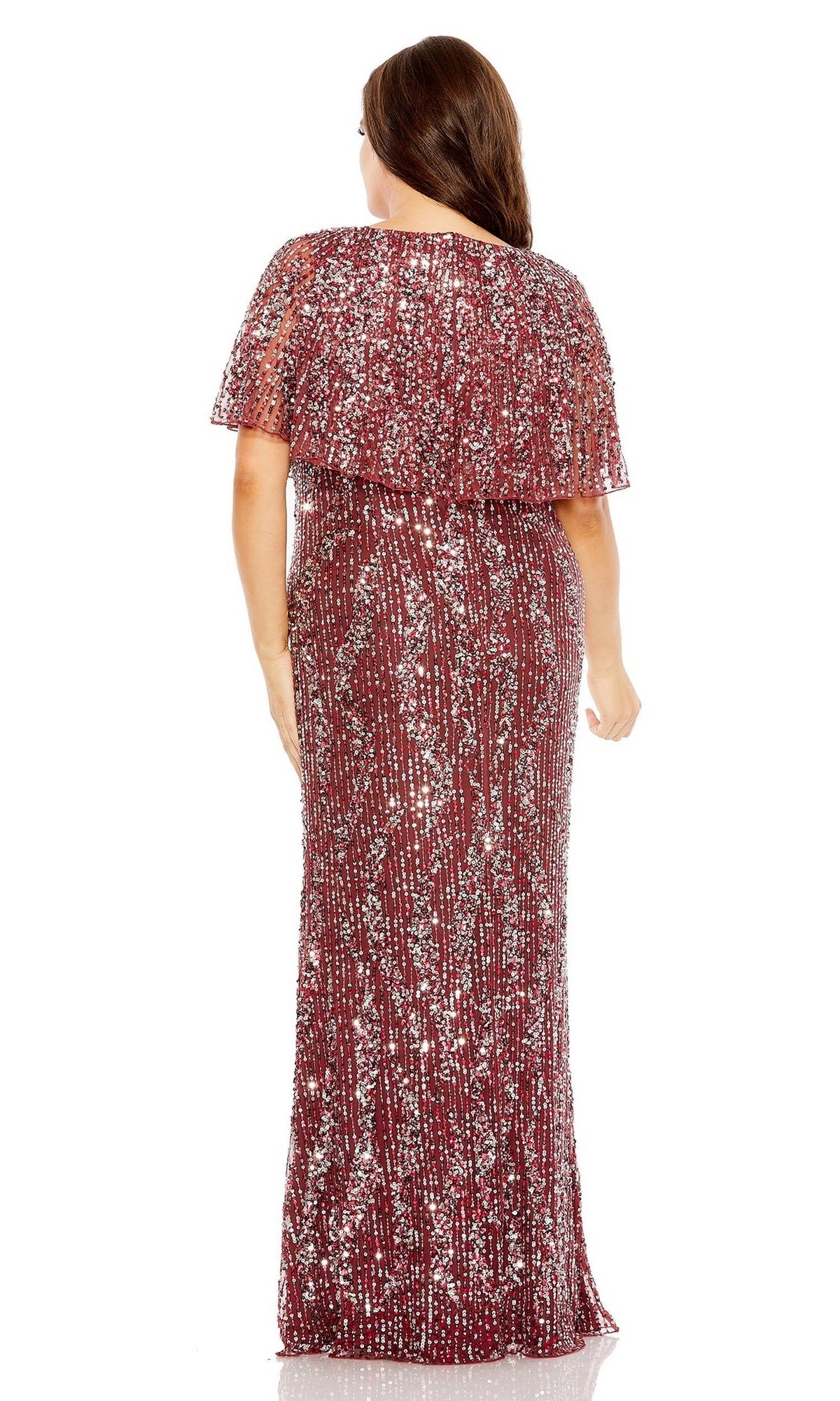 A woman faces away in a floor-length, short-sleeve burgundy Mac Duggal 93867 plus-size long sequin prom dress with a cape overlay, set against a white background.