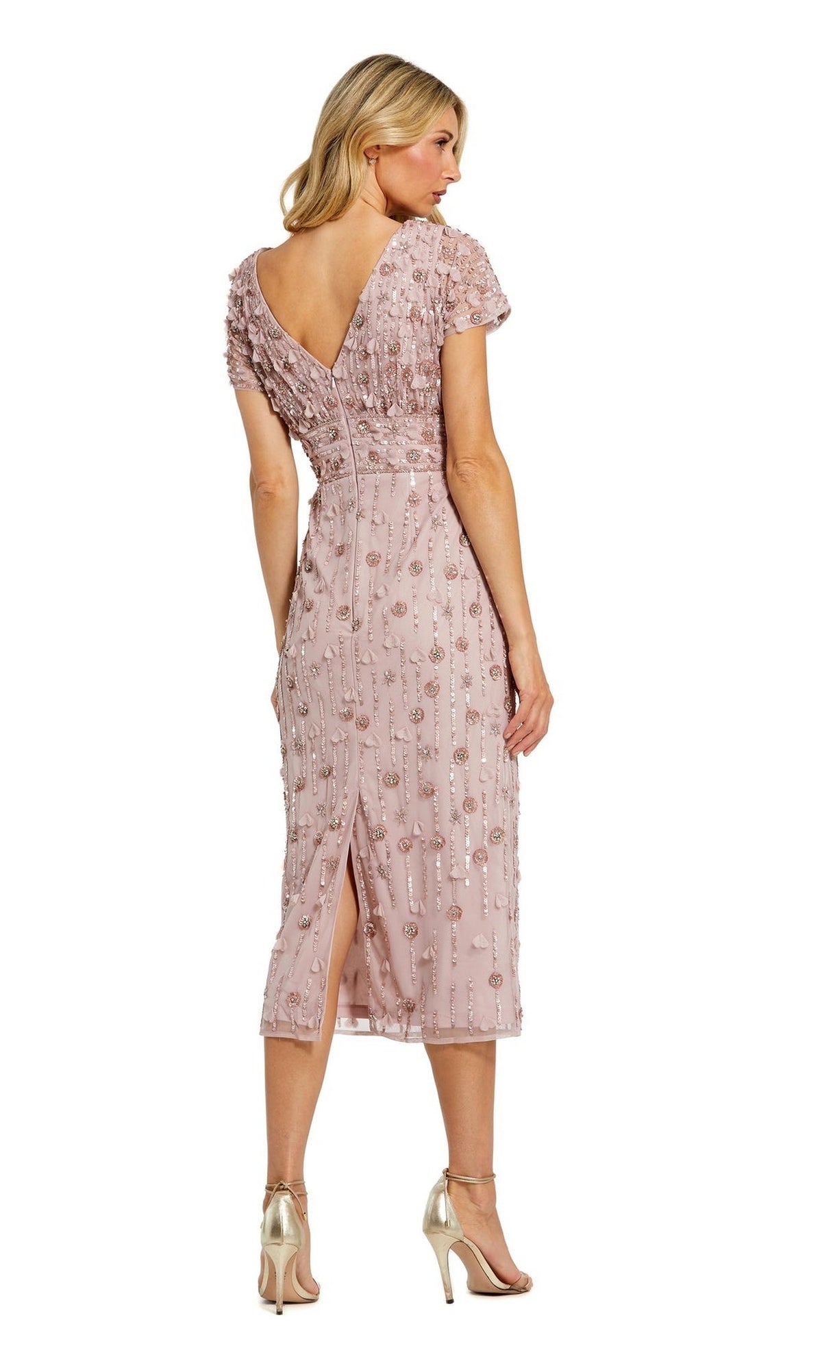 A woman faces away, wearing the Mac Duggal Beaded Midi Wedding-Guest Dress 94117 with pink sequin stripes, floral beading, short sleeves, a V-back, and gold high-heeled sandals.