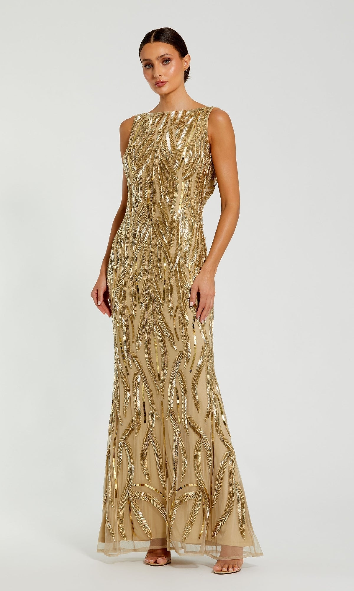 A woman poses against a white background in the Mac Duggal 94146 Long Formal Dress, a sleeveless, floor-length gold gown adorned with sequins and bead detailing.