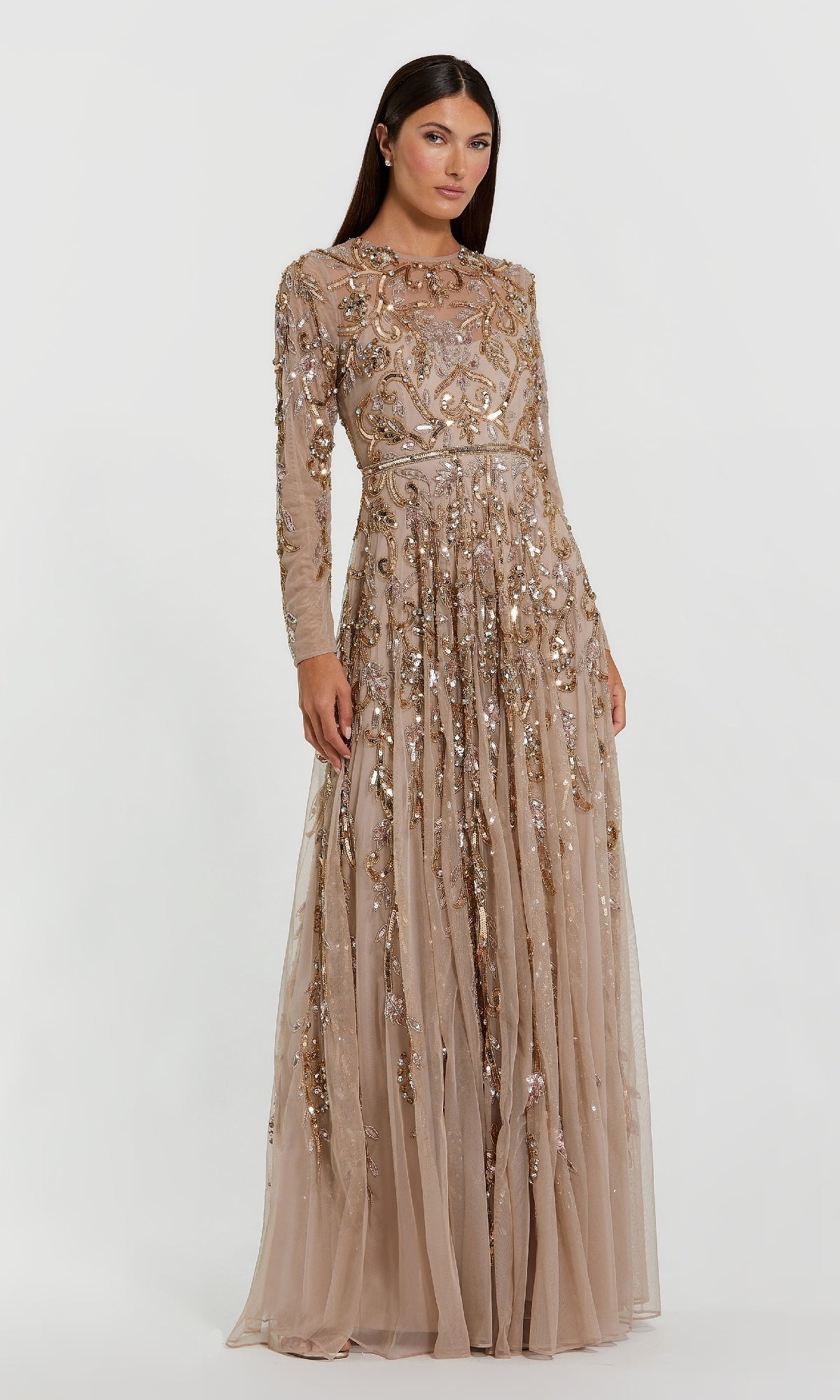 A woman poses against a white background in the Mac Duggal 94213 long beaded gold formal dress, featuring a floor-length nude gown adorned with gold sequins and embroidery.