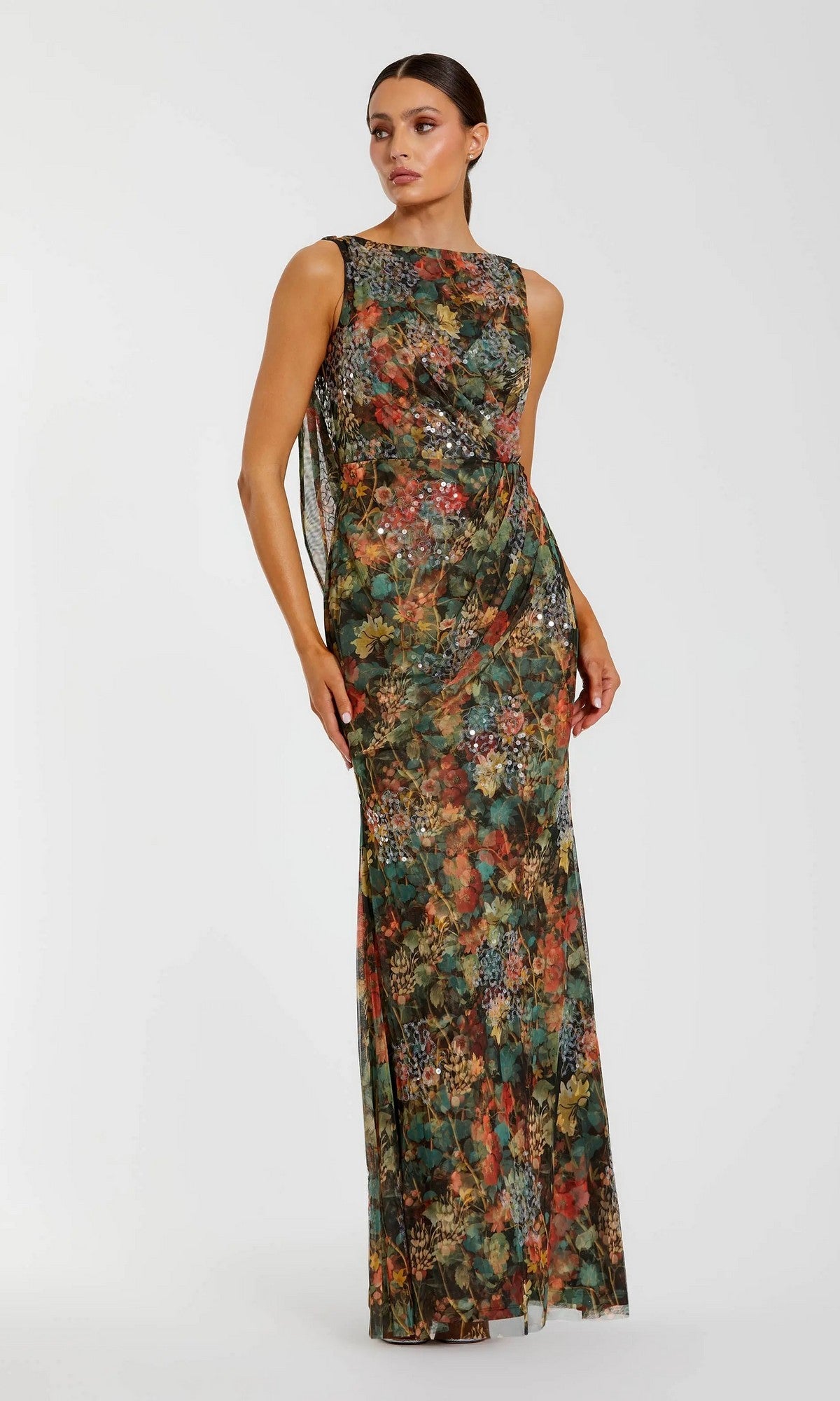 A woman stands against a plain white background wearing the Mac Duggal 94263 Long Formal Dress, a sleeveless, floor-length gown with a multicolor floral pattern.