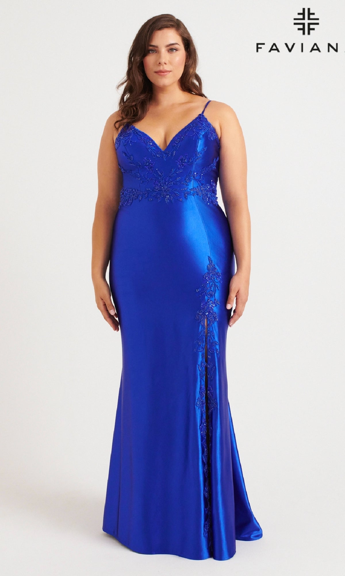 A woman models the Faviana 9562 Long Plus-Size Prom Dress in royal blue satin with lace details, thin straps, a V-neckline, and a side slit.