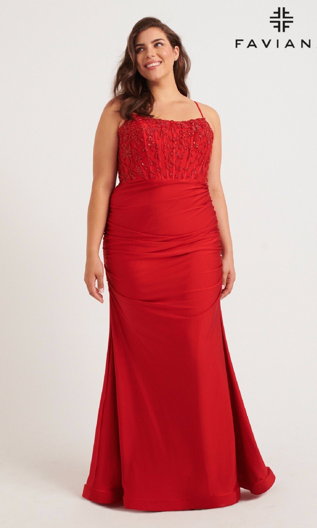 A woman models the Long Plus-Size Prom Dress: Faviana 9569—a red, floor-length stretch charmeuse gown with thin straps and a beaded corset bodice—standing against a plain background. The