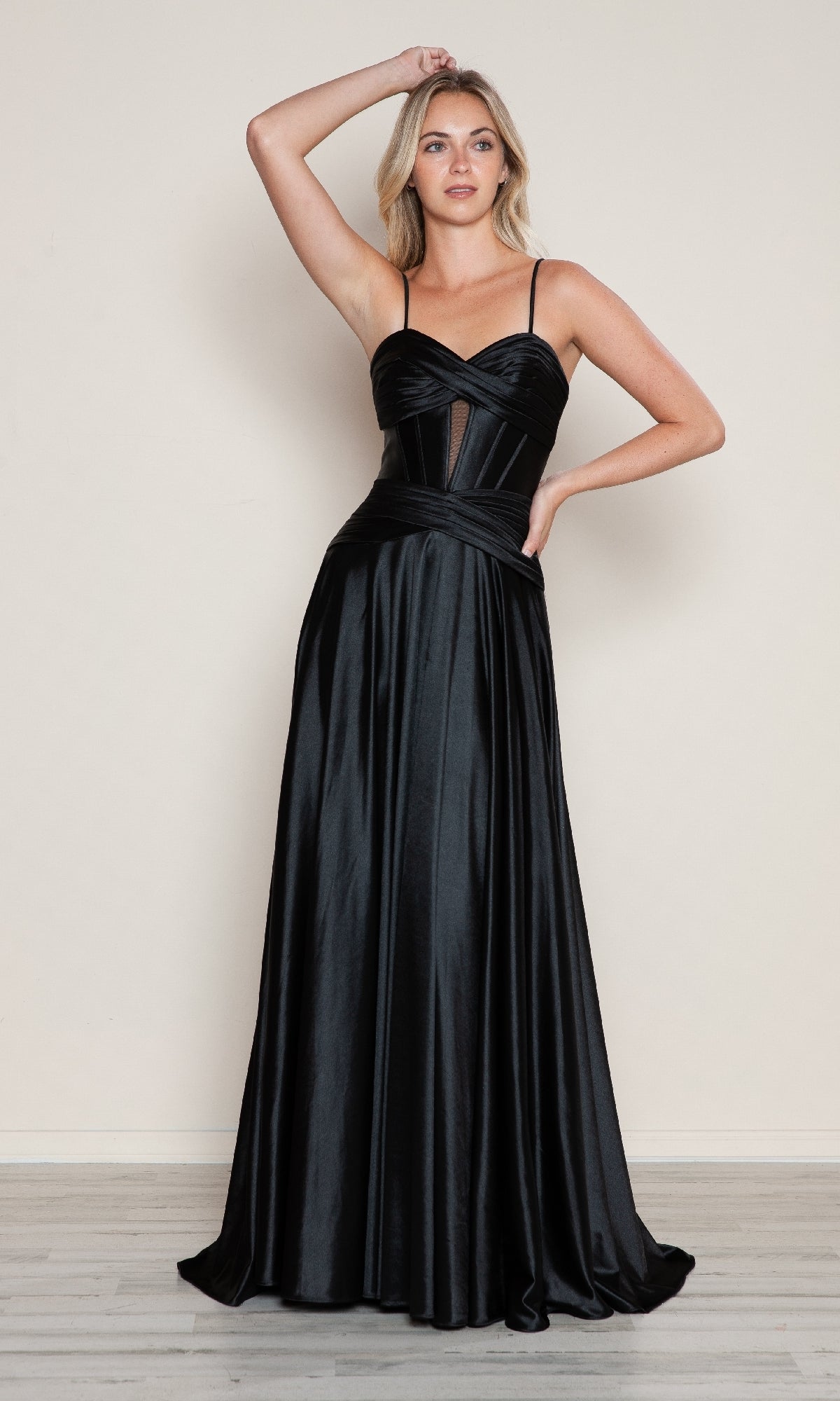 A woman poses against a plain background in the Cut-Out Long A-Line Prom Dress: Poly USA 9700, featuring a sleek black satin design with thin straps and a fitted bodice—ideal for any formal dress occasion.