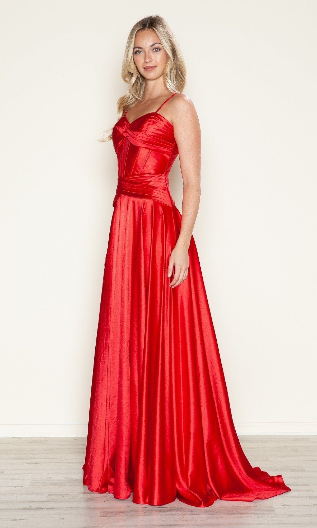 A woman stands against a plain light background wearing the Poly USA 9700 Cut-Out Long A-Line Prom Dress—a floor-length, sleeveless red gown with a fitted bodice and flared skirt.