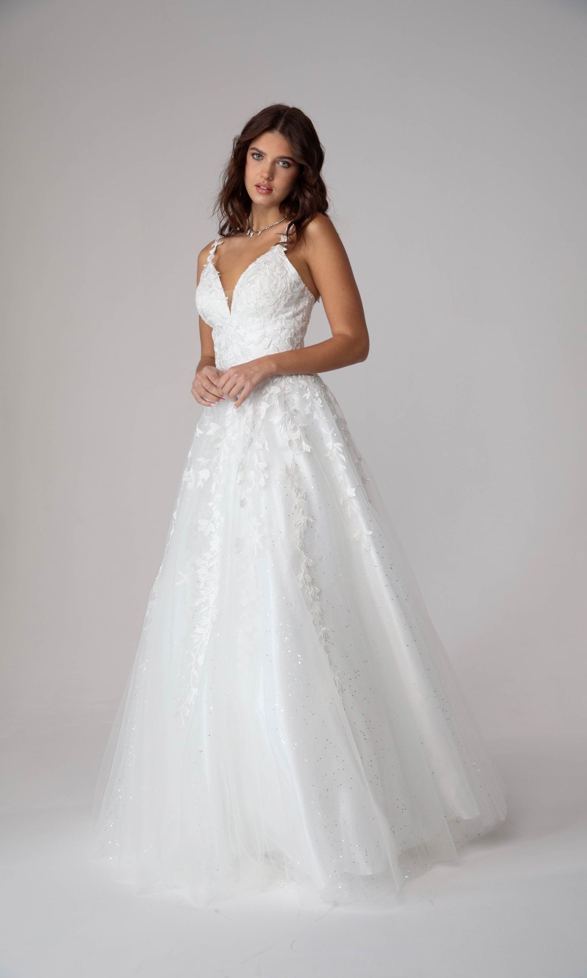 A woman models the Embroidered-Lace Long Prom Dress Eureka 9858, featuring a sleeveless fitted bodice with lace embroidery and a flowing tulle skirt, set against a plain light background.
