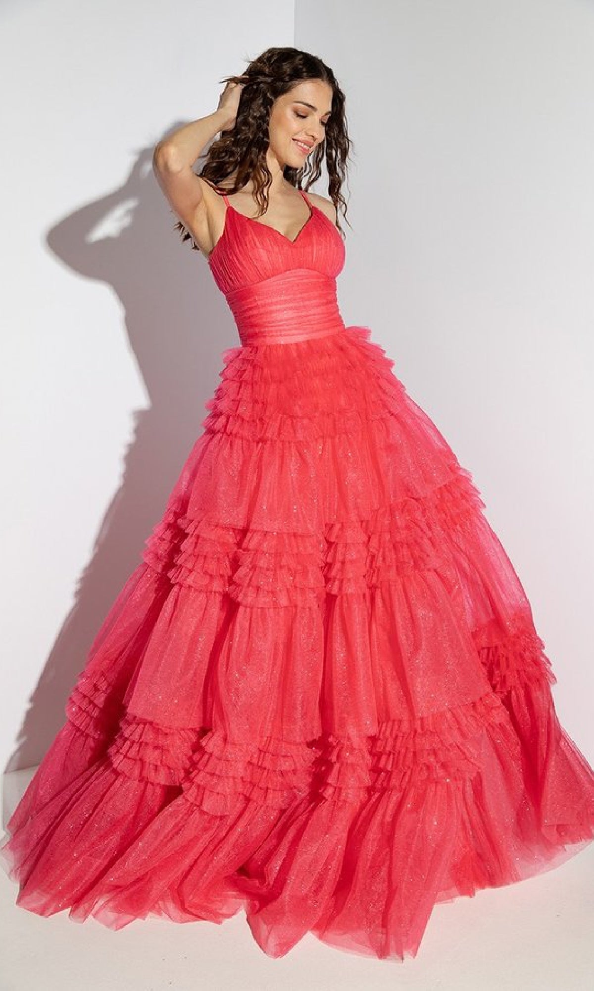 A woman models the Lace-Up Long Glitter-Tulle Prom Dress (Eureka 9888), a bright pink, floor-length gown with ruffles, spaghetti straps, and a chic lace-up back, against a plain white background.