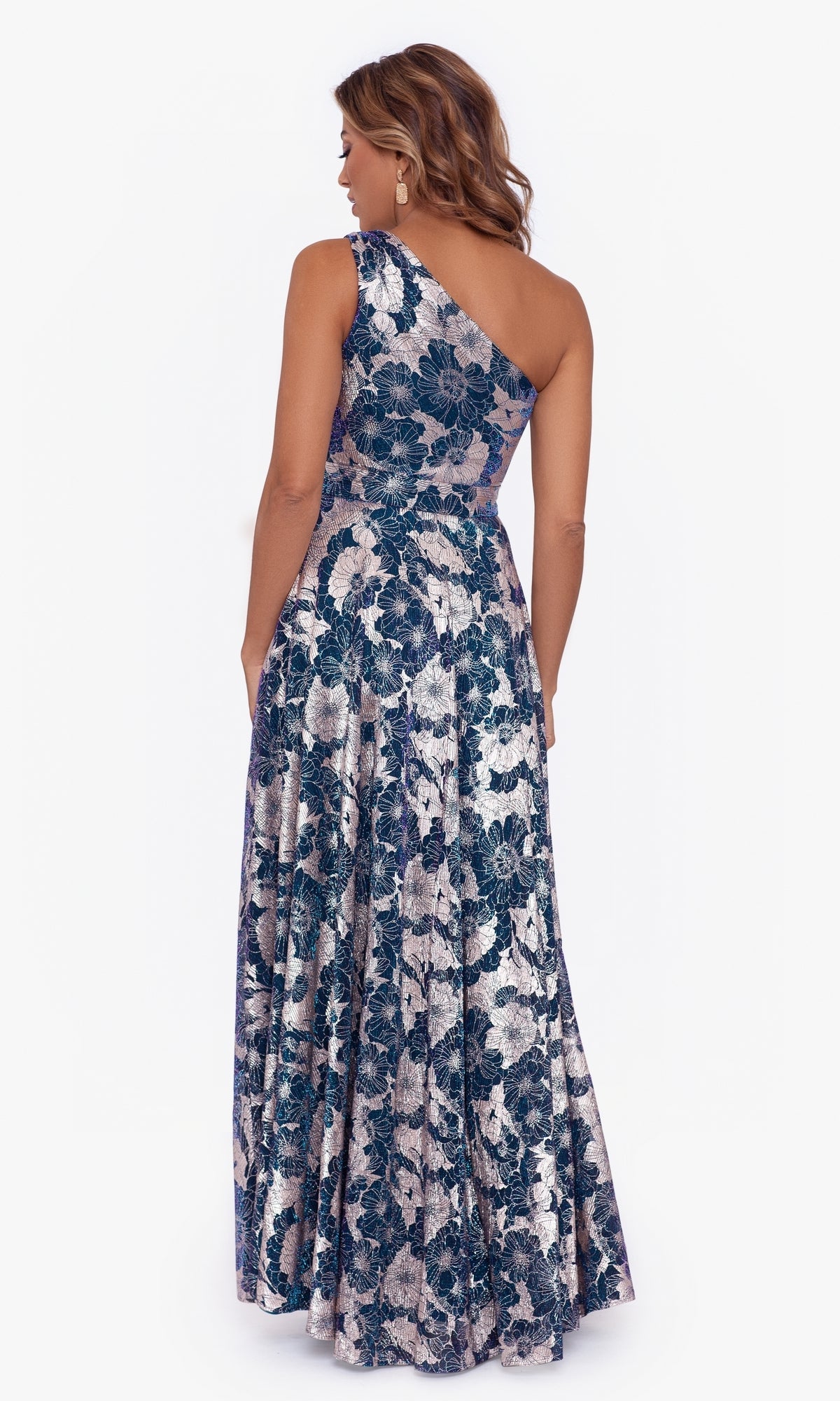 A woman faces away, wearing the One-Shoulder Floral-Print Long Formal Dress A25113, featuring a blue and silver floral pattern—ideal for an elegant evening gown look.
