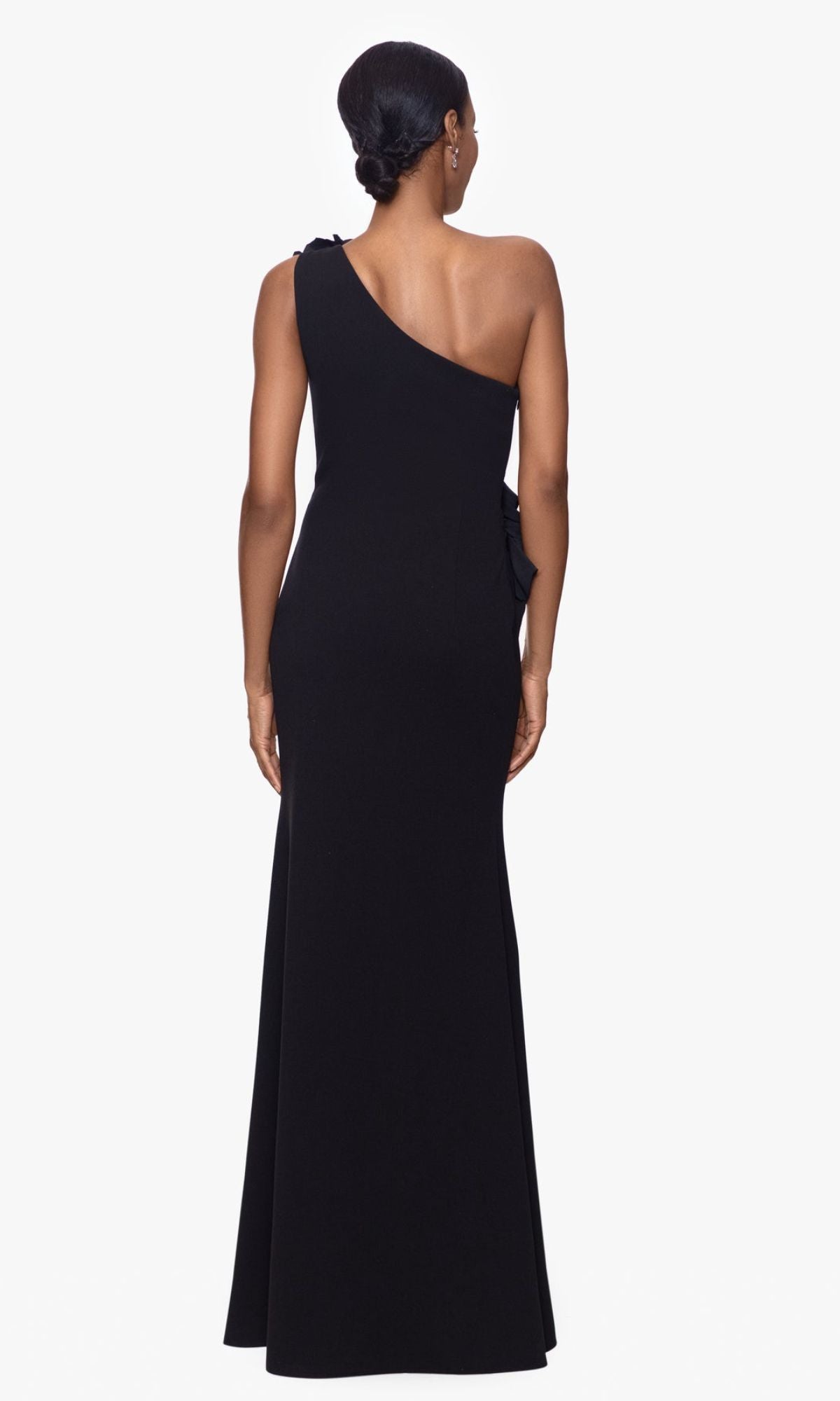 A woman faces away, wearing the Betsy and Adam One-Shoulder Long Prom Dress A26071—a black fitted formal gown that's perfect for any elegant evening occasion.