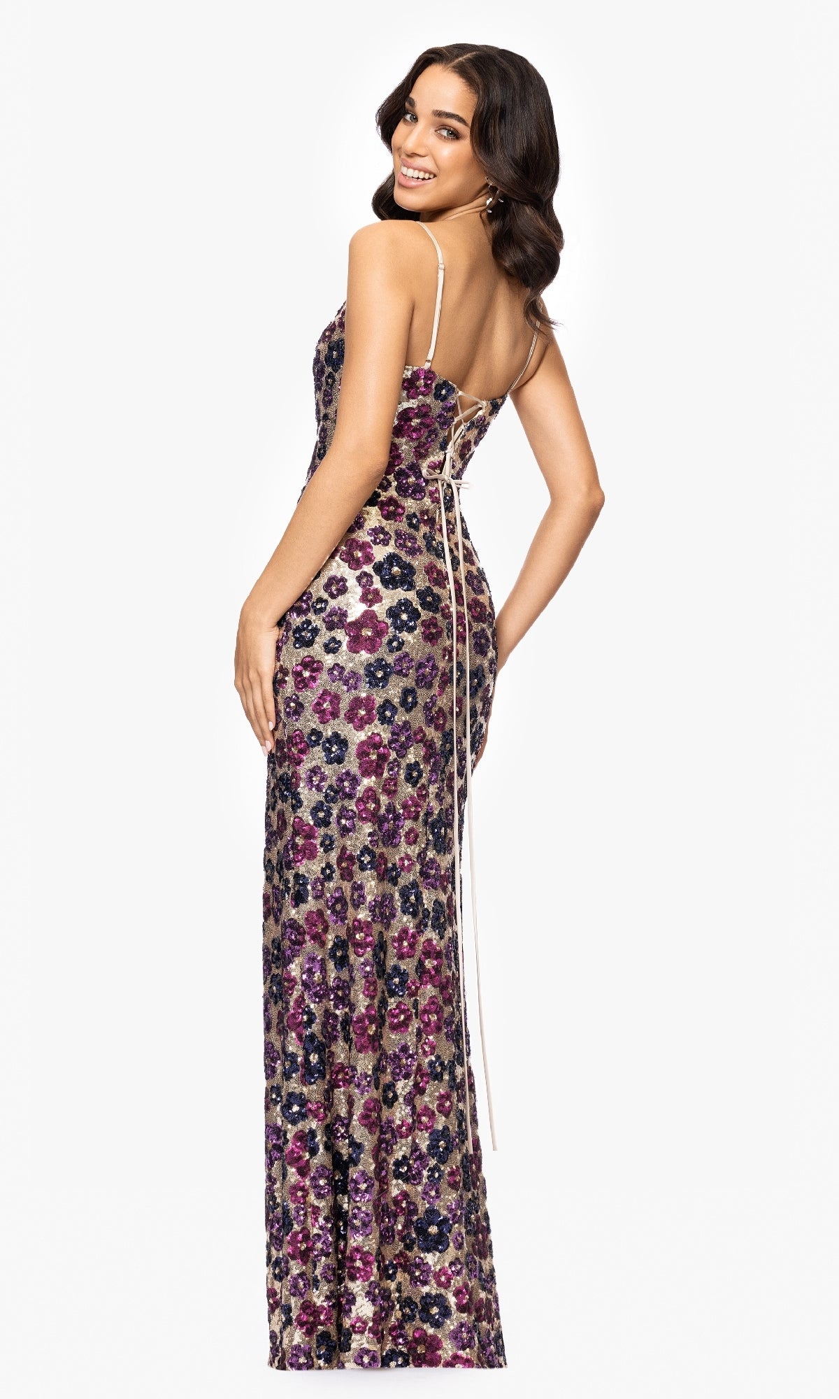A woman models the Floral-Sequin Long Prom Dress: Betsy & Adam A27017, a floor-length, sleeveless gown with thin straps, floral sequins, and a lace-up back for a standout prom look.