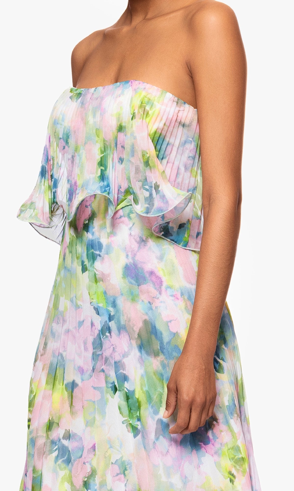 Someone wearing the Betsy & Adam A27018 Strapless Wedding Guest Gown, a long floral-print dress with pleats in pastel green, blue, pink, and purple shades—ideal for making a stylish statement at any wedding.