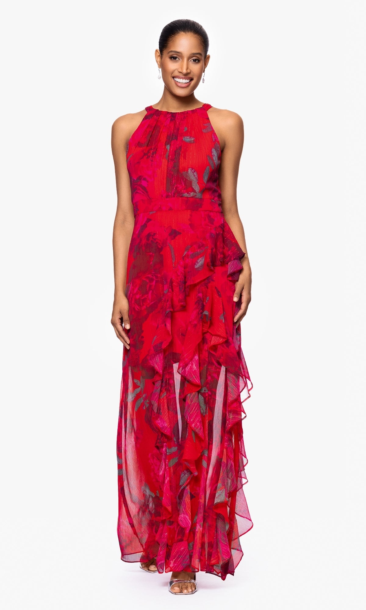 Woman standing and smiling, wearing the Betsy & Adam A27036 Long Red Floral Formal Dress with ruffles and open-toe heels against a plain white background.