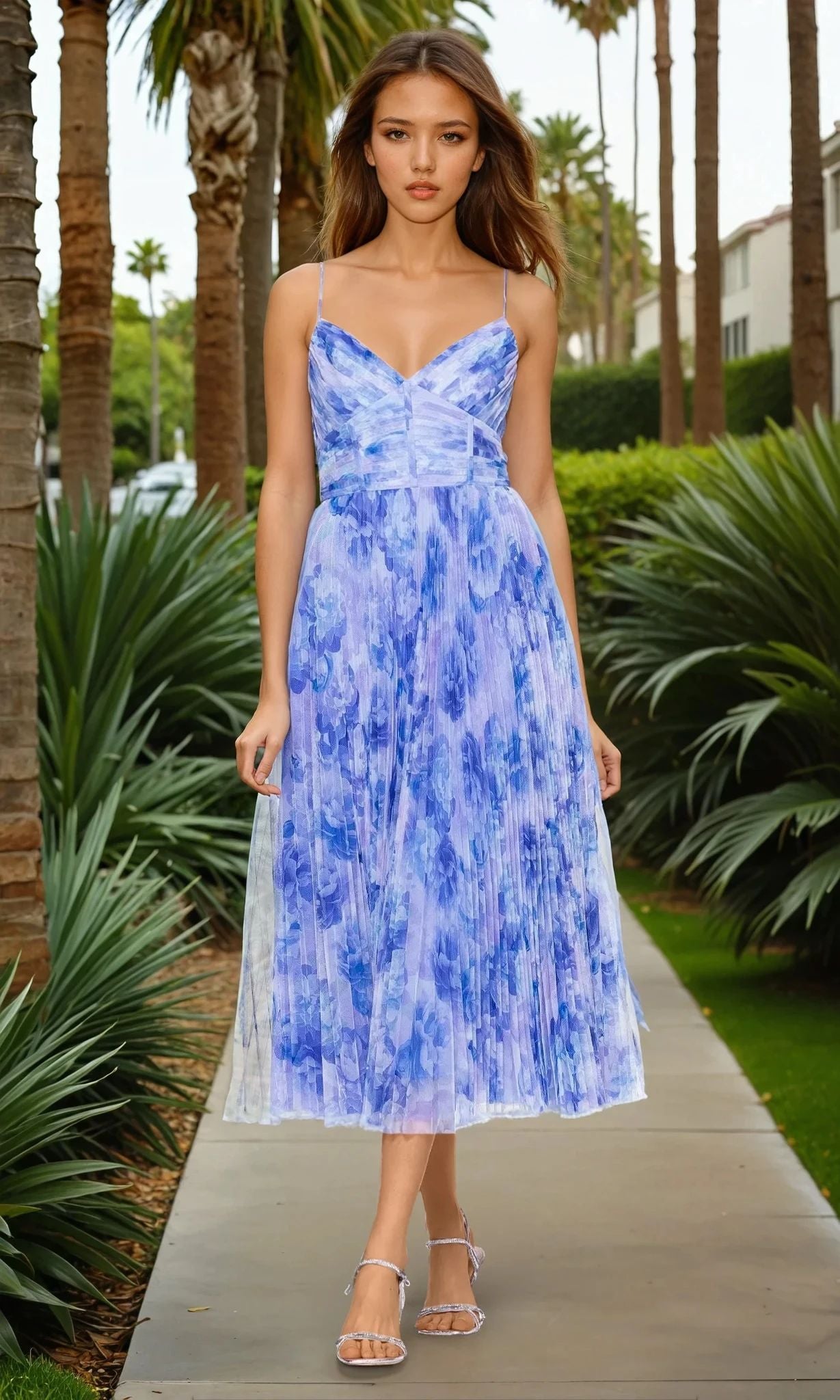 A woman walks on a palm-lined sidewalk, wearing the Betsy & Adam A27053 blue floral midi wedding guest dress with a structured bodice and clear-strap sandals.